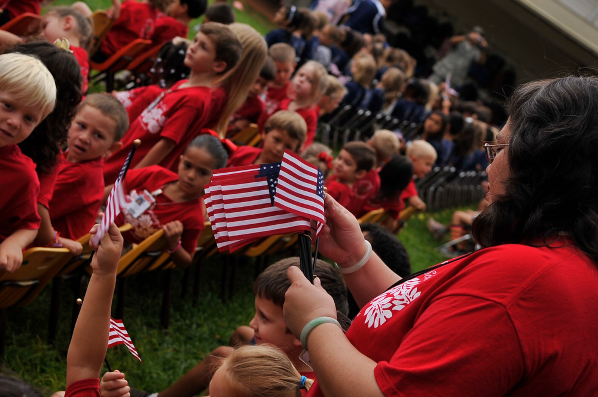 JOINT BASE PEARL HARBOR-HICKAM, Hawaii - Hickam Elementary School teacher, Mrs. JeAnn Williams passes out flags to her kindergarten class during the school's Second Annual 9/11 Observance Ceremony held on Sept. 10 at Joint Base Pear Harbor-Hickam, Hawaii. More than 750 students from Hickam Elementary participated in the ceremony with the help of their teachers, parents and the Radford High School Color Guard and Band. (U.S.  Air Force photo/Tech Sgt. Cohen A. Young)