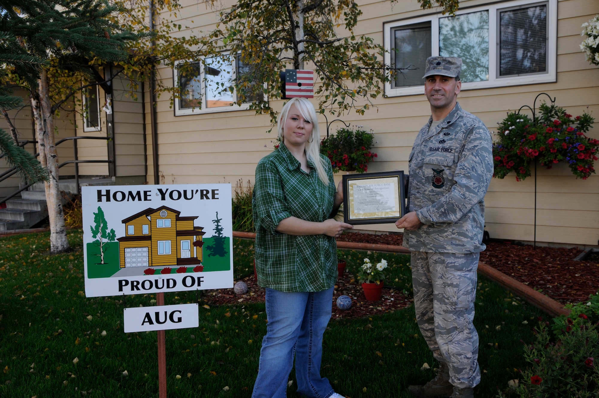 Chante Freeman displays their "Home You're Proud Of " award with 354th Civil Engineer Squadron commander Lt. Col. Michael Sheredy Sept. 10, 2010, Eielson Air Force Base, Alaska.  Each winning household recieves gift cards from various units on base and businesses off base. Not pictured is Staff Sgt. Ashley Freeman who is assigned to the 354th Aircraft Maintenance Squadron and currently deployed. (U.S. Air Force photo/Airman 1st Class Yash Rojas)