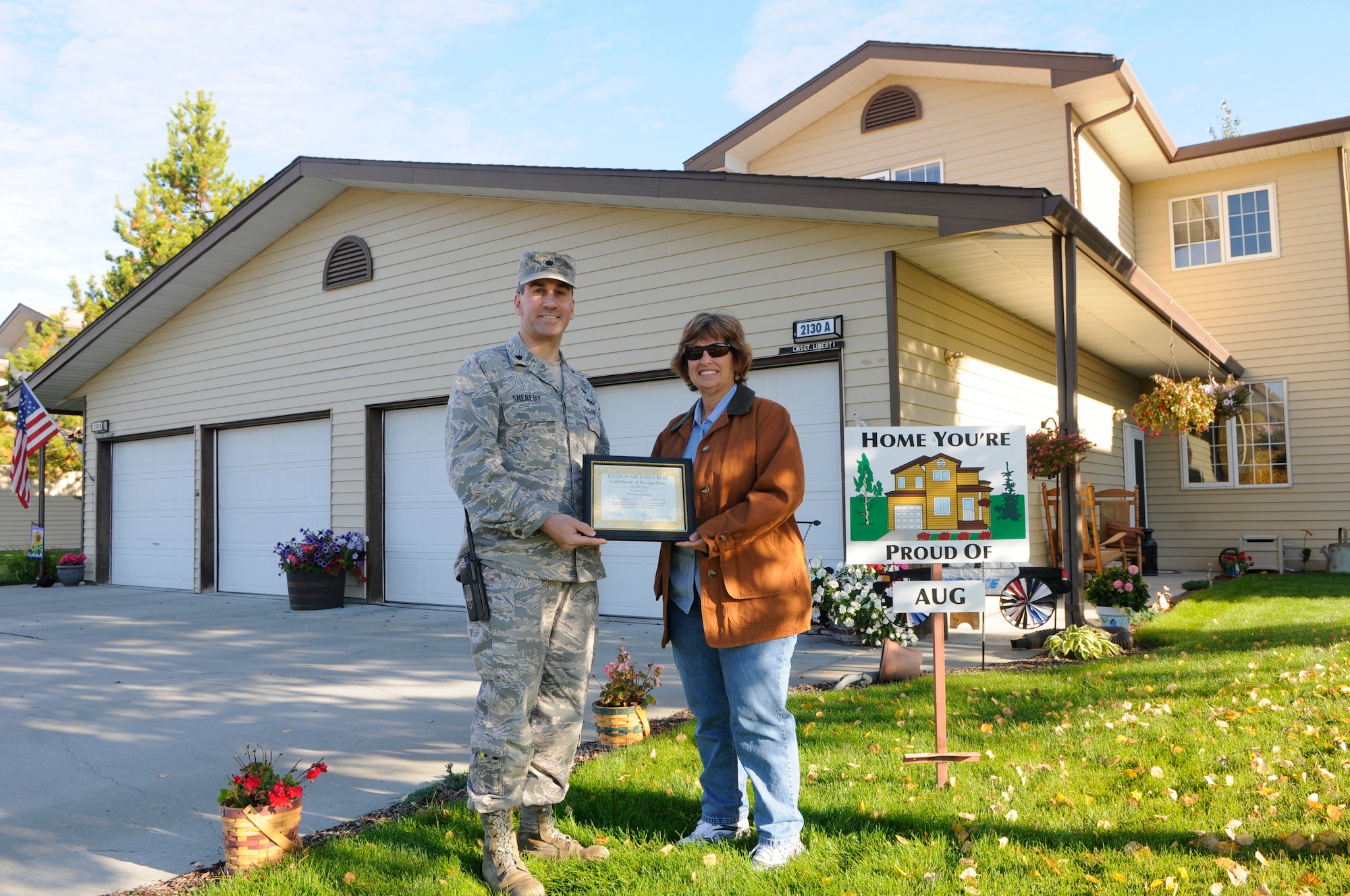 Gwenn Liberti displays their "Home You're Proud Of" award with 354th Civil Engineer Squadron commander Lt. Col. Michael Sheredy Sept. 10, 2010, Eielson Air Force Base, Alaska.  Each winning household recieves gift cards from various units on base and businesses off base.  Chief Master Sgt. Nicholas Liberti is assigned to the 354th Security Forces Squadron. (U.S. Air Force photo/Airman 1st Class Yash Rojas)