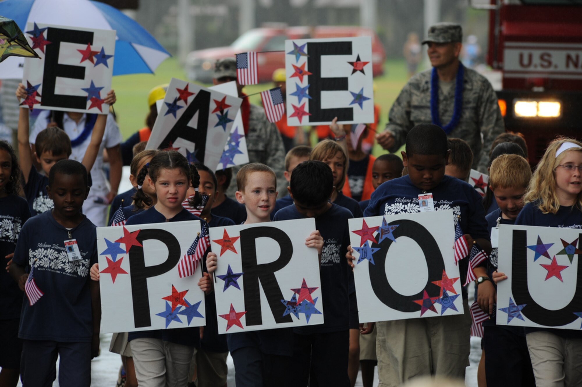 JOINT BASE PEARL HARBOR-HICKAM, Hawaii - Fourth Graders from Hickam Elementary School, Joint Base Pear Harbor-Hickam, Hawaii dispaly thier signs and message during their school's parade in the rain on Sept. 10 as part of their Second Annual 9/11 Observance Ceremony. More than 750 students from Hickam Elementary participated in the ceremony with the help of their teachers, parents, the Fire Dept. and the Radford High School Color Guard and Band. (U.S.  Air Force photo/Tech Sgt. Cohen A. Young)