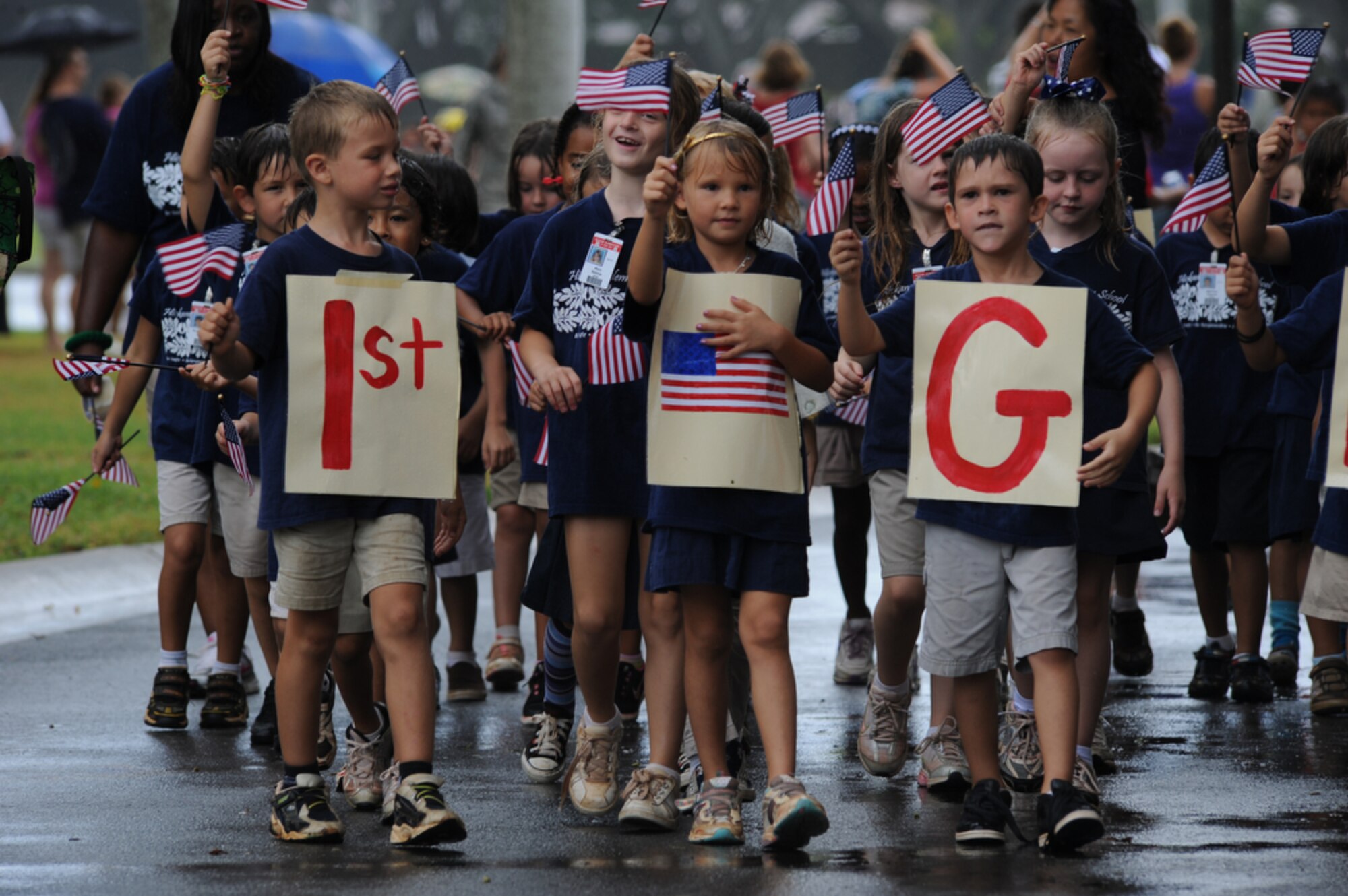 JOINT BASE PEARL HARBOR-HICKAM, Hawaii - First Graders from Hickam Elementary School, Joint Base Pear Harbor-Hickam, Hawaii wave their flags during their school's parade in the rain on Sept. 10 as part of their Second Annual 9/11 Observance Ceremony. More than 750 students from Hickam Elementary participated in the ceremony with the help of their teachers, parents and the Radford High School Color Guard and Band. (U.S.  Air Force photo/Tech Sgt. Cohen A. Young)