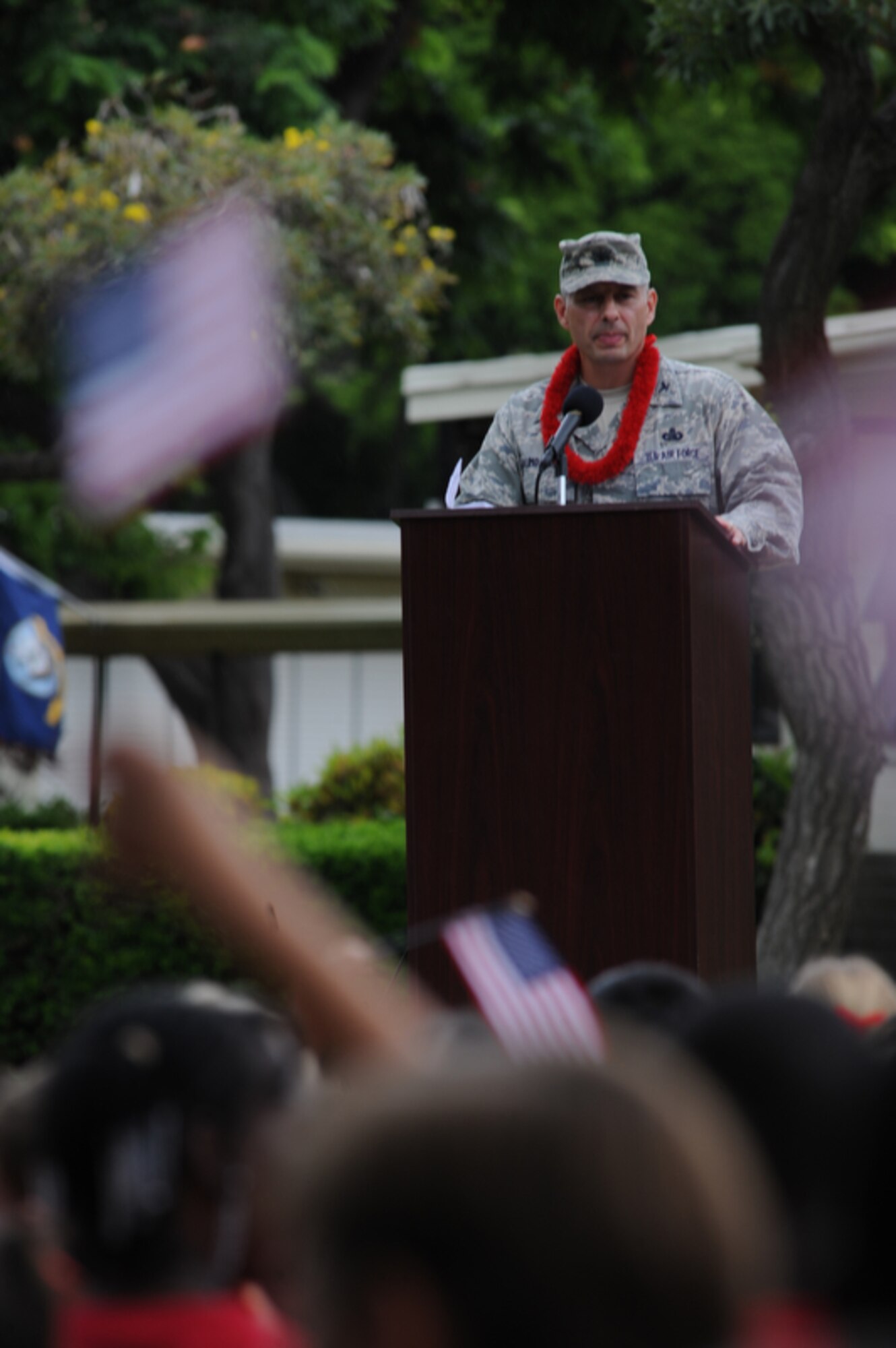 JOINT BASE PEARL HARBOR-HICKAM, Hawaii - Hickam Elementary students waive their flags while 647th Air Base Group Commander Col. Charles Baumgardner makes remarks honoring the victims of the Sept. 11 terrorist attacks during a 9/11 ceremony held on Joint Base Pearl Harbor-Hickam, Hawaii on Sept. 10. (U.S.  Air Force photo/Tech Sgt. Cohen A. Young)