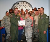 LAUGHLIN AIR FORCE BASE, Texas – Senior Airman Chelsae Wetherbee, 47th Operations Support Squadron, poses with fellow members of her squadron after being presented the XLer of the Week award by Col. Michael Frankel, 47th Flying Training Wing commander, Sept. 8. The XLer is a weekly award chosen by 47th FTW leadership and given to individuals who consistently make outstanding contributions to Laughlin and their unit. (U.S. Air Force photo by Airman 1st Class Blake Mize)