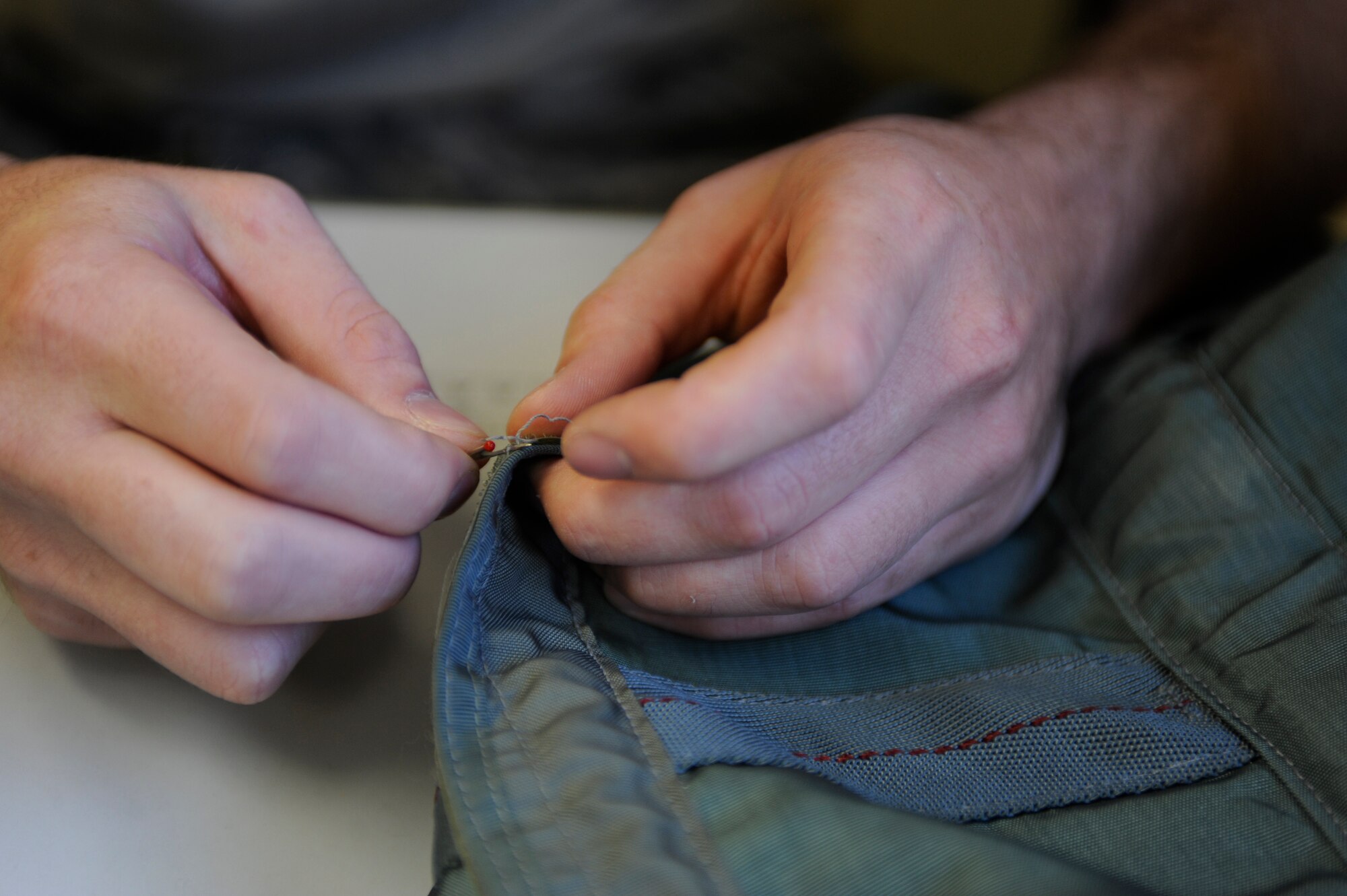 Airman 1st Class Jerred Brown rips out old seams Sept. 13, 2010, Eielson Air Force Base, Alaska. If seams are damaged, they must be torn out and replaced to ensure the reliability of the aircrew's survival equipment. Airman Brown is a Aircrew Flight Equipment Apprentice assigned to the 354th Aircrew Flight Equipment. (U.S. Air Force photo/Senior Airman Willard E. Grande II)