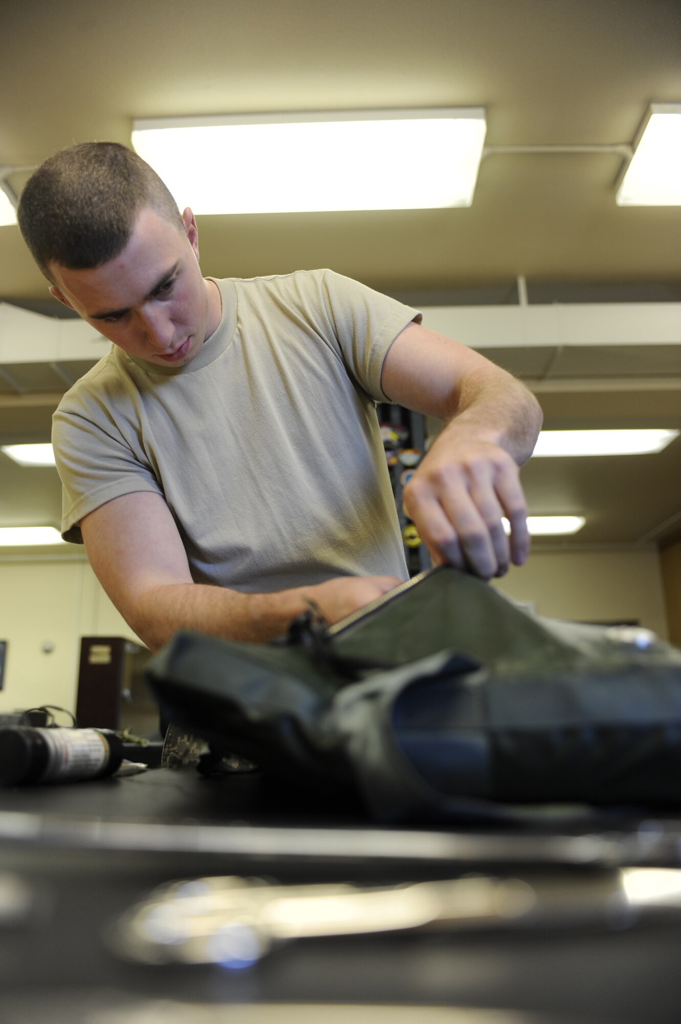 Airman 1st Class Jerred Brown packs a survival kit Sept. 13, 2010, Eielson Air Force Base, Alaska. Necessary survival equipment is packed expertly to ensure there is no damage to items and everything fits properly. Airman Brown is an Aircrew Flight Equipment Apprentice assigned to the 354th Aircrew Flight Equipment. (U.S. Air Force photo/Senior Airman Willard E. Grande II)