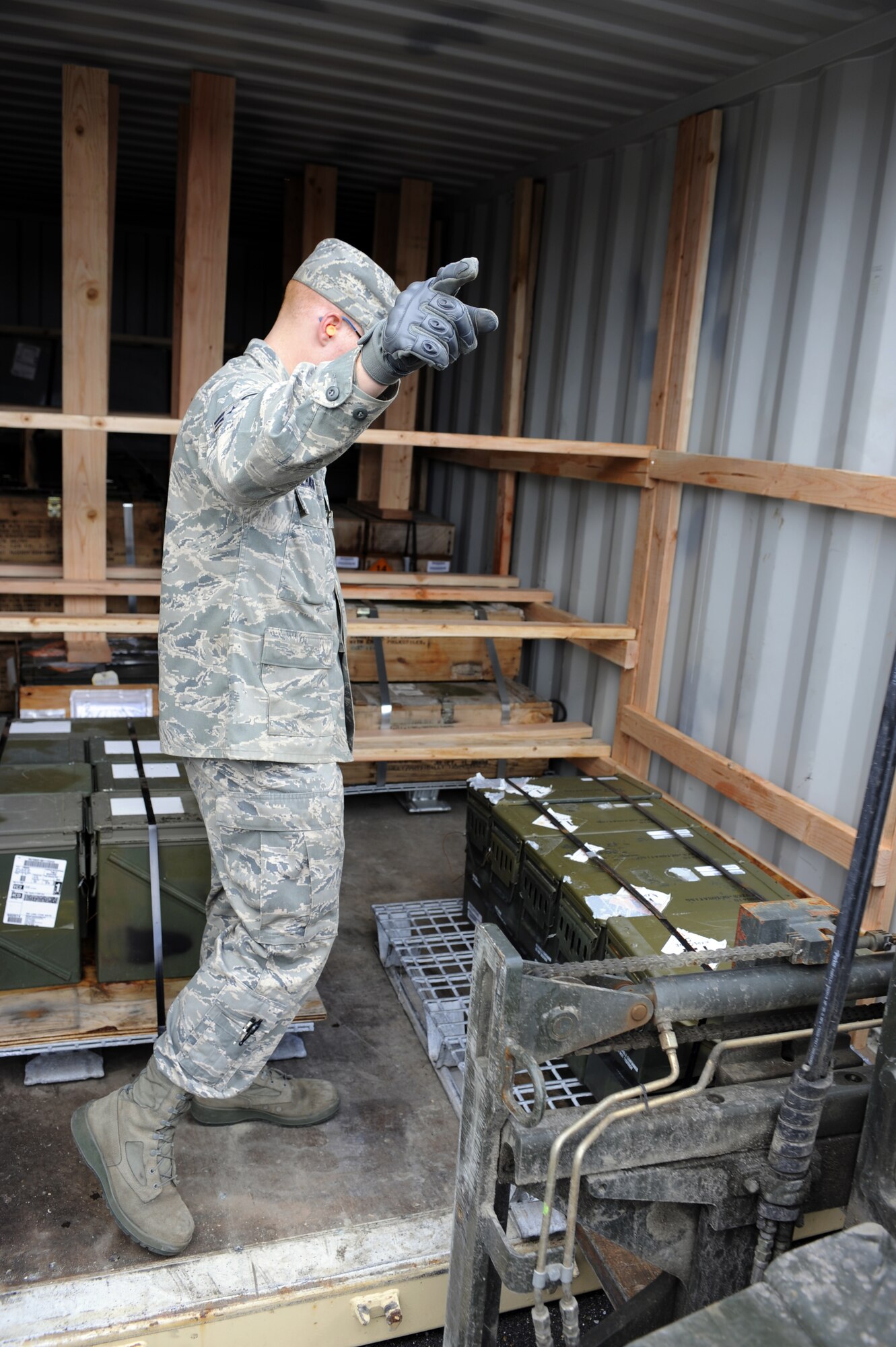Senior Airman Jordan Wilkinson guides unserviceable munitions into a shipping container Sept. 9, 2010, Eielson Air Force Base, Alaska. This movement is part of an annual shipment where unserviceable munitions are sent back to the lower 48. Airman Wilkinson is a crew member assigned to the 354th Munitions Storage Flight. (U.S. Air Force photo/Senior Airman Willard E. Grande II)