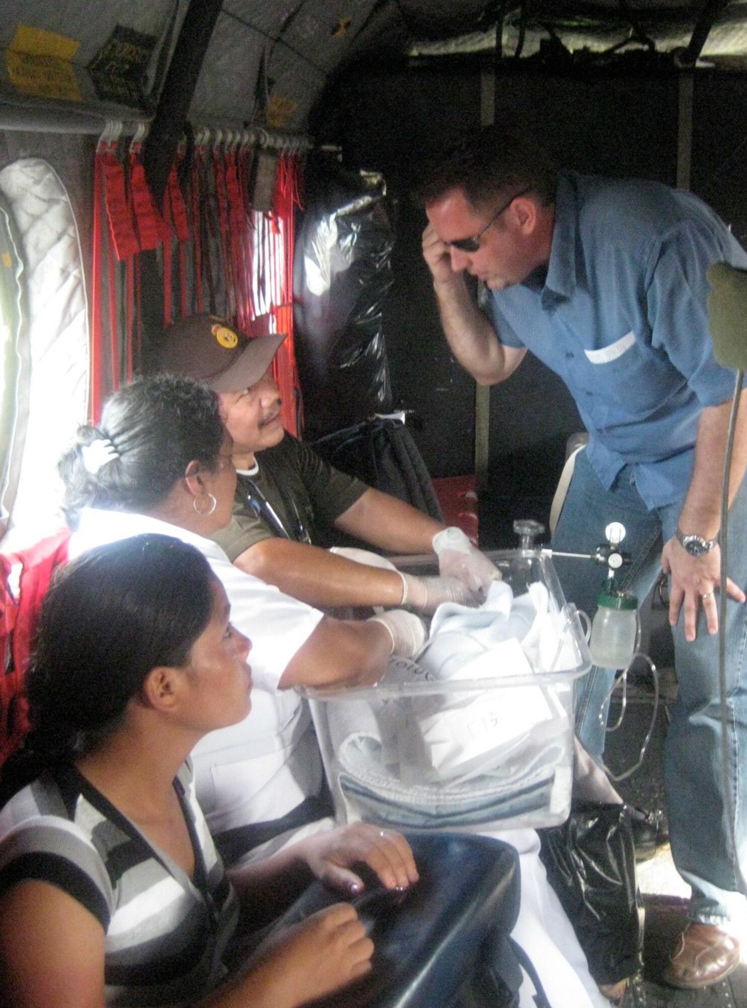 BLUEFIELDS, Nicaragua --  Doctors and family members keep watch over a baby as he was evacuated aboard a 1-228th Aviation Regiment CH-47 Chinook helicopter to receive emergency medical care in Managua, Nicaragua. The baby was in critical condition and had to be transported while inside of an incubator. The 1-228th crew was able to safely get the baby to an ambulance near a hospital. (Photo by 1st Lt. Mike Jeter)