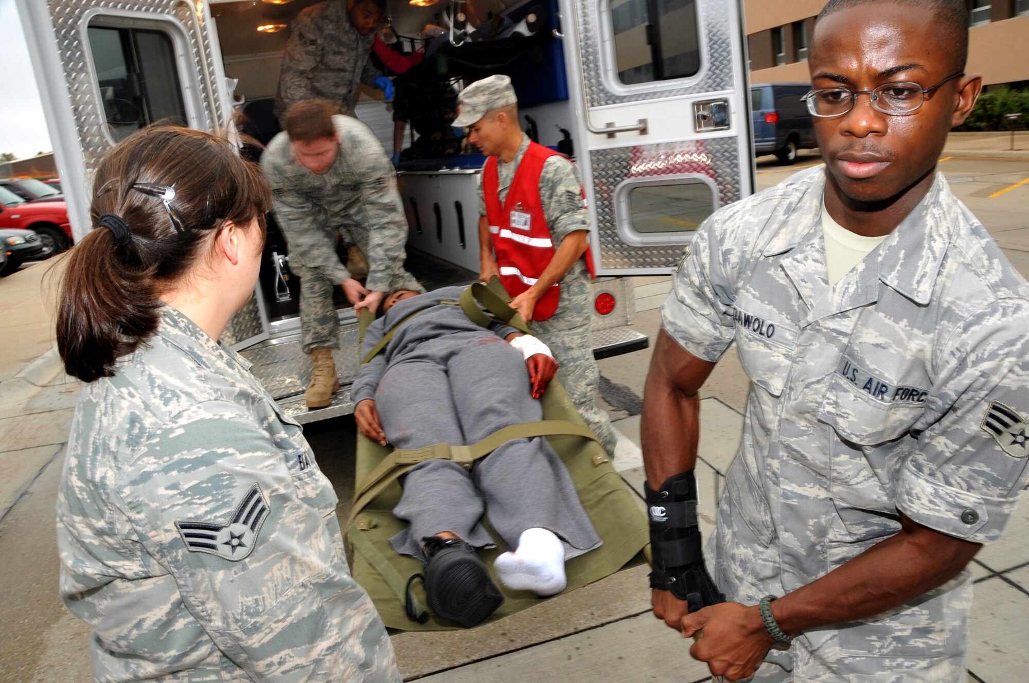 OFFUTT AIR FORCE BASE, Neb. - Airmen 1st Class Annah Bates and Isaac Zawolo, 55th Medical Group, help unload a simulated victim from an ambulance Sept. 10 as part of an active shooter exercise on base. Team Offutt's first responders conduct various exercise scenarios throughout the year to prepare for possible threats to people and resources.  U.S. Air Force photo by Jeff W. Gates