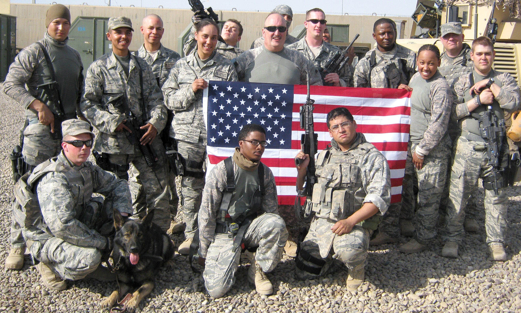 Members of the unit two Vance security forces Airmen deployed to support in Iraq pose for a group photo. Airman 1st Class Tynisia Hains, holding the left corner of the flag, and Airman 1st Class Jordan Brown, kneeling in front of the stars on the flag, recently returned from their deployment. Both are assigned to the 71st Security Forces Squadron at Vance. (Photo contributed by Airman 1st Class Tynisia Hains)