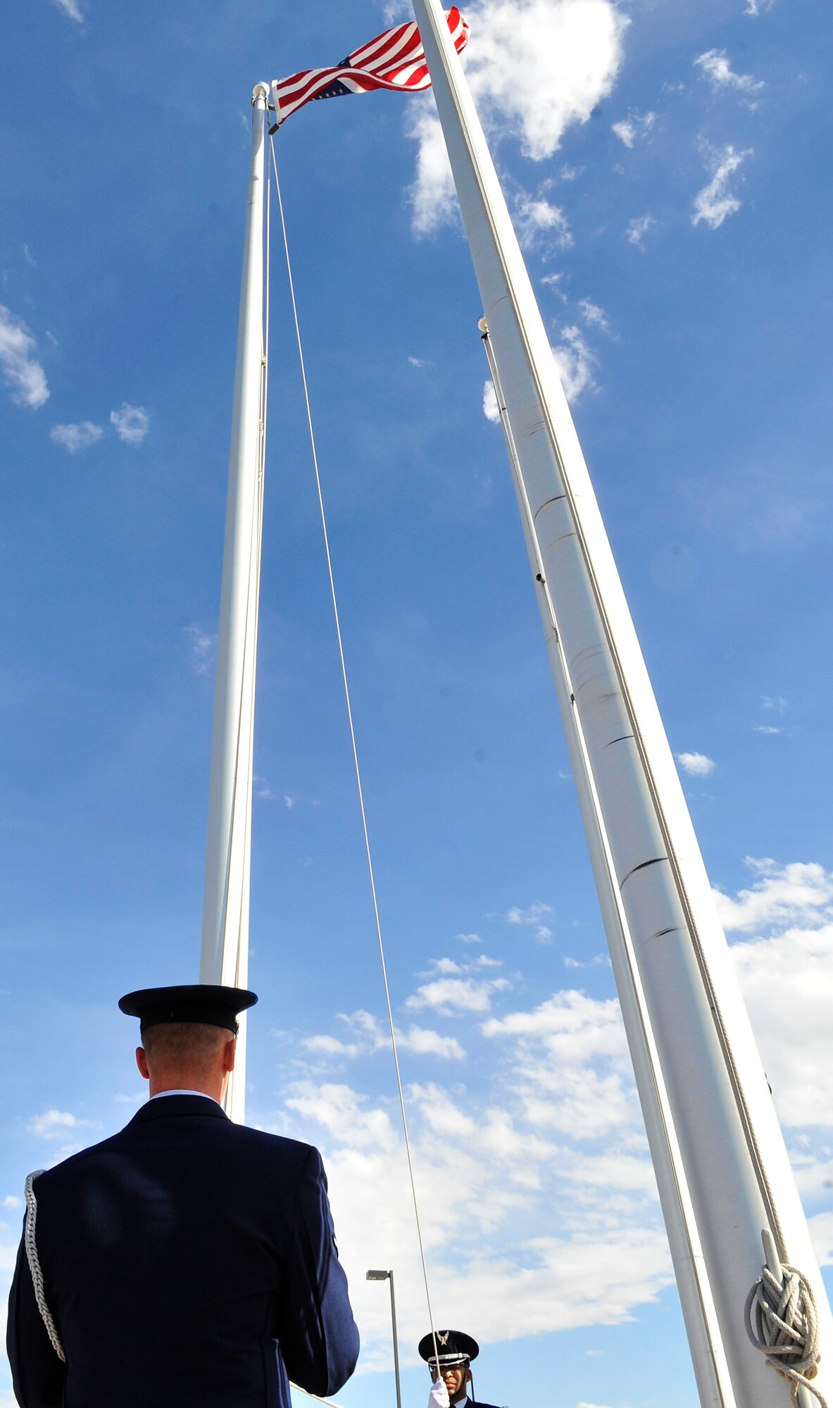 BUCKLEY AIR FORCE BASE, Colo. -- Air Force Honor Guard members lowered the American flag during a remembrance ceremony Sept. 10. The president directed that the American flag would be flown at half-staff  at individual American homes, at the White House, and on all U.S. government buildings and establishments in the U.S. and abroad. (U.S. Air Force photo by Airman 1st Class Paul Labbe)