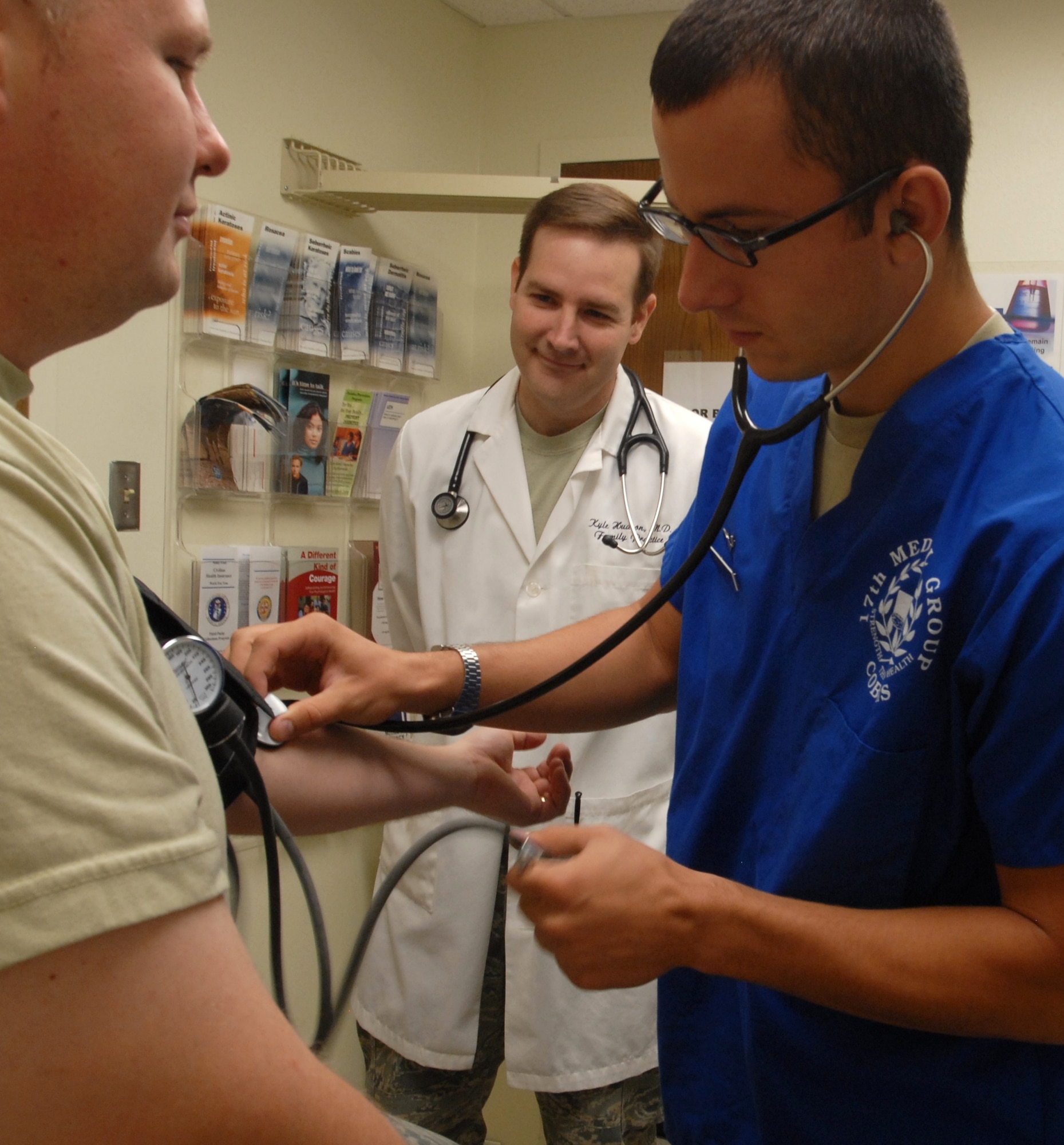 Airman 1st Class Eli Petrenko, 17th Medical Group Medical Technician, checks a patient’s blood pressure during an appointment with Maj. (Dr.) Kyle Hudson. The Family Health Initiative, a program designed to increase patient and clinic staff satisfaction, starts at the 17th MDG family practice clinic Sept. 20. (U.S. Air Force photo/Connie Hempel)