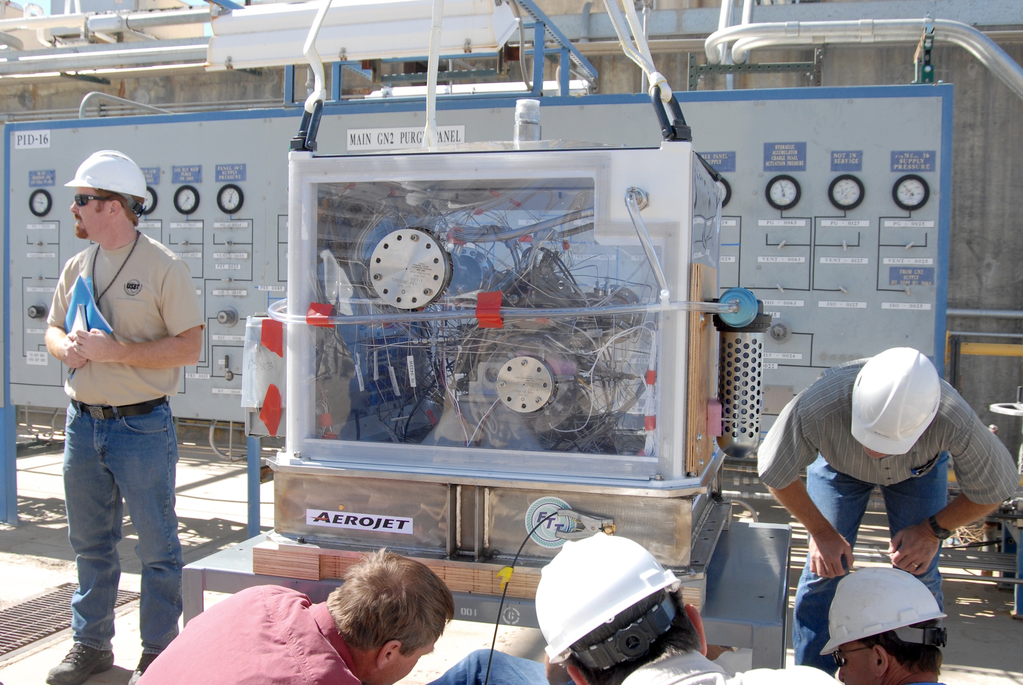 Air Force Research Laboratory workers make necessary adjustments before lifting the Upper Stage Engine Technology turbo pump with a crane to attach it to AFRL's 2A rocket test stand. The USET turbo pump produces about 4,000 horsepower and will propel the upper stage portion of a rocket into space once the lower stage booster is detached. (U.S. Air Force photo/Kenji Thuloweit)