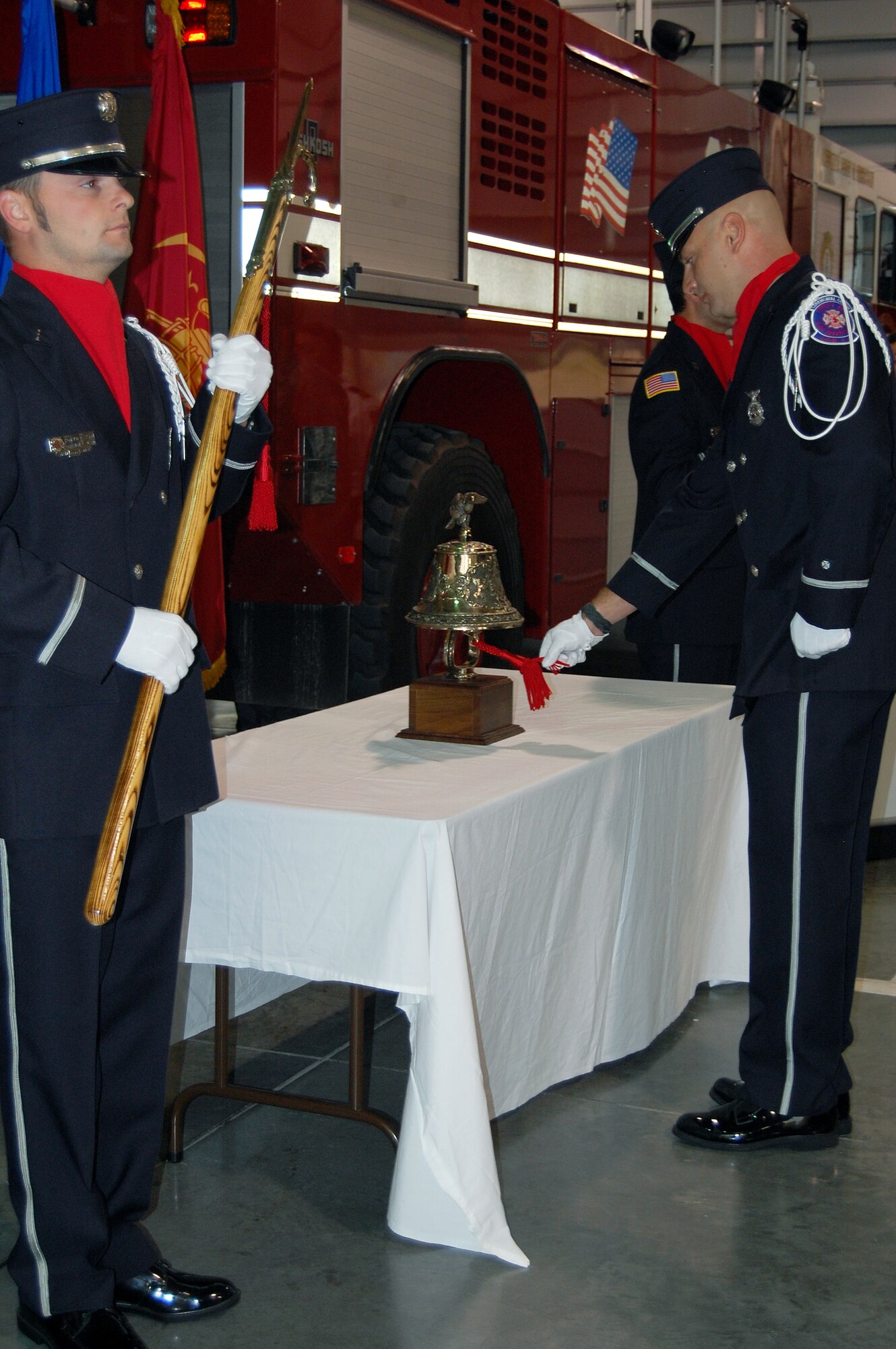 OFFUTT AIR FORCE BASE, Neb. - Ceremonial guard member Firefighter Brent Bergstrom rings the fire station bell as part of the Offutt Fire Department's 9/11 Remembrance Ceremony Sept. 10 in the bay of the fire station while ceremonial guard member Firefighter Ron Dawson stand at attention.  The annual ceremony, held during morning roll call, included the final alarm given to honor firefighters who have lost their lives in the line of duty. According to Station Chief Roger Filter, the tradition of the final alarm, consiting of two sets of five bell rings, dates back to the days of horse and buggy firefighters when alarm boxes were located around cities so people could notify fire departments of fires. They were also used  to notify citizens of the death of a firefighter.  U.S. Air Force photo by Debbie Aragon