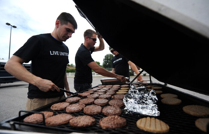 Volunteers cook up beef and soy burgers for hungry workers after a long day of volunteering during the United Way's National Day of Caring Sept. 10, 2010 in the city of Charleston, S.C. Pulled pork, burgers, coleslaw, beans, chips and drinks were quickly devoured by volunteers who completed more than 15 various projects assigned to the Air Force. (U.S. Air Force photo/Senior Airman Timothy Taylor)
