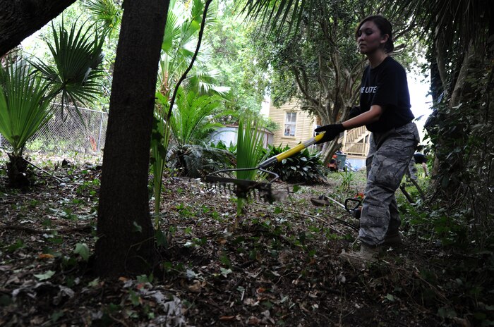 Airman 1st Class Alyssa Pruitt racks up debris from a landscaping project during the United Way's National Day of Caring Sept. 10, 2010 in the city of Charleston, S.C. Airmen cut trees, collected trash and pulled vines during the renovation of this backyard. Several truck loads later, volunteers made this backyard a friendly and hospitable environment for the owners. Airman Pruitt is a food service apprentice with the 628th Force Support Squadron. (U.S. Air Force photo/Senior Airman Timothy Taylor)