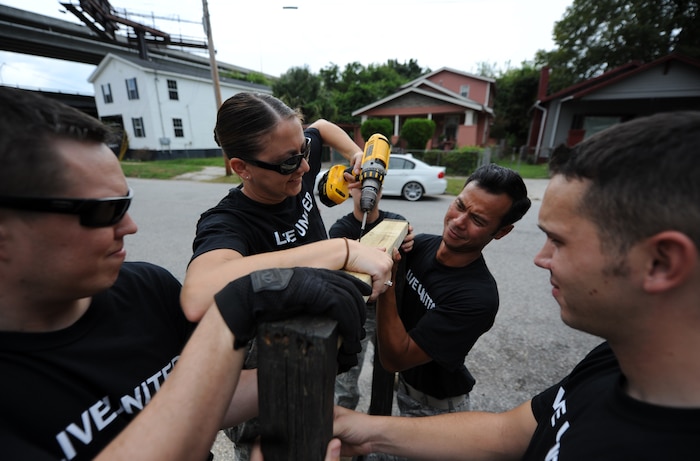 Air Force volunteers secure a new 2x4 to a weathered wooden gate during the United Way's National Day of Caring Sept. 10, 2010 in the city of Charleston, S.C. The City of Charleston provided a budget of $1,500 dollars for more than 30 requested projects. (U.S. Air Force photo/Senior Airman Timothy Taylor)