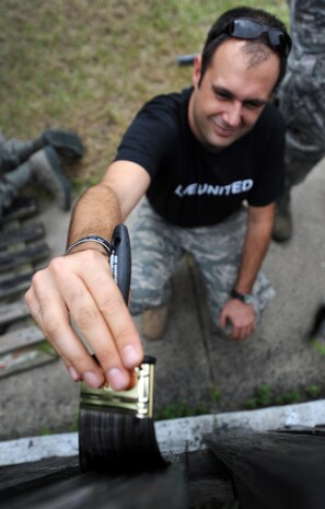 Tech. Sgt. Steve Gore applies a coat of black paint on a newly installed wooden fence during the United Way's National Day of Caring Sept. 10, 2010 in the city of Charleston, S.C. Volunteers spent eight hours fixing, cleaning, renovating and renewing local residences to show their support for the local community. Sergeant Gore is a loadmaster with the 16th Airlift Squadron. (U.S. Air Force photo/Senior Airman Timothy Taylor) 
