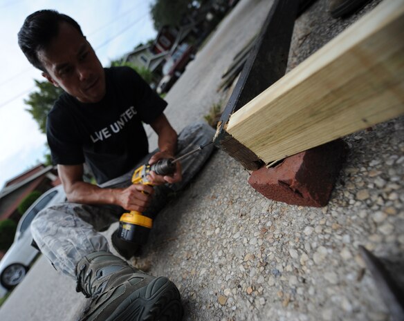 Tech. Sgt. Cao Nguyen drives a screw into the corner of a wooden gate during the United Way's National Day of Caring Sept. 10, 2010 in the city of Charleston, S.C. Joint Base Charleston supplied more than 800 Air Force, Navy and nuclear power training command student volunteers to assist local citizens with landscaping, painting, organizing, debris removal and the installation of new smoke alarm systems. Sergeant Nguyen is a crew chief instructor with the 437th Mission Operations Squadron. (U.S. Air Force photo/Senior Airman Timothy Taylor)