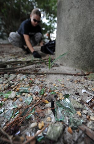 2nd Lieutenant Melissa Allan collects glass at the base of an overpass column during the United Way's National Day of Caring Sept. 10, 2010 in the city of Charleston, S.C. Air Force volunteers spruced up a playground under an overpass, clearing it of glass, rubble and trash making it a safer and cleaner environment for children to play in. Lieutenant Allan is the acting photo flight commander at the 1st Combat Camera Squadron. (U.S. Air Force photo/Senior Airman Timothy Taylor)