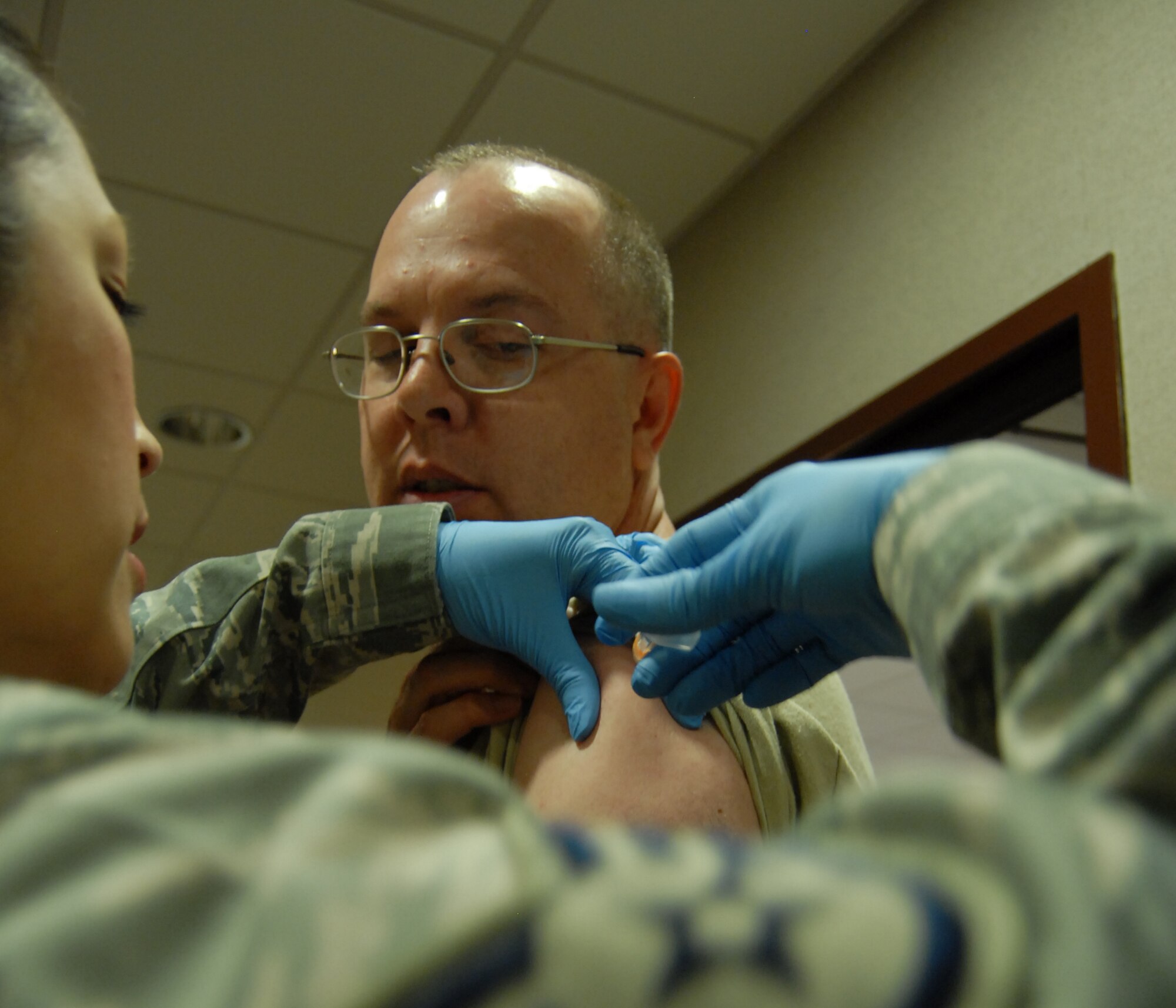GOODFELLOW AIR FORCE BASE, Texas -- Staff Sgt. Gisela Williams, 17th Medical Operations Squadron, injects Col. David Rearick, 17th Training Wing vice commander, with a stain of flu vaccine in the halls of the command building Sept. 14. The visit was a early kick off for the 2010 flu season, which runs Oct. through March 2011. (U.S. Air Force photo/ Senior Airman Tong Duong) 