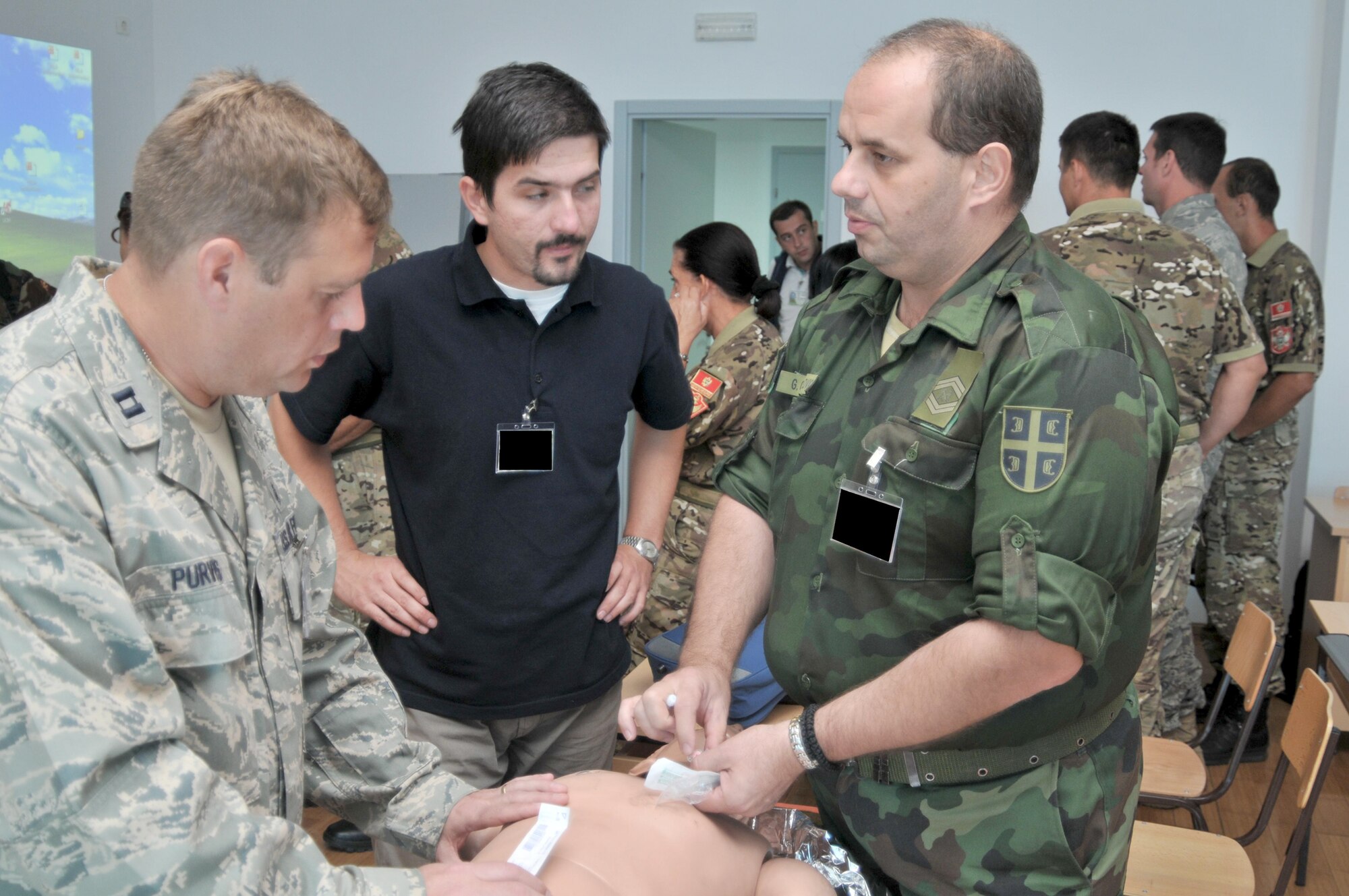 Capt. Charles Purvis, (left) discusses treatment Sept. 14, 2010 for a collapsed lung with Marko Saric, a physician's assistant from Bosnia and Herzegovina and Serbian army Warrant Officer Goran Gavrilovic at Medical Training Exercise in Central & Eastern Europe 2010 held at Danilovgrad Army Base, Montenegro. Captain Purvis is a critical care nurse from the 48th Medical Operations Squadron at RAF Lakenheath England. (U.S. Air Force photo/Senior Airman David Dobrydney)