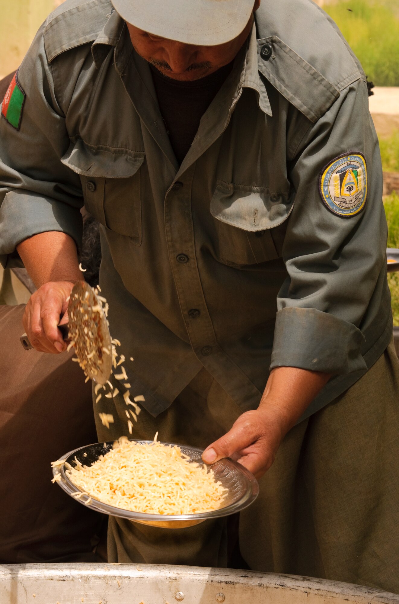 FORWARD OPERATING BASE BULLARD, Afghanistan - An Afghan National Police officer prepares a rice dish for a meal after an election shura held at the Shah Joy District Center, Shah Joy District, Zabul province, Sept. 13. Shah Joy District Chief Abdul Qayum invited local elders to the district center to discuss the upcoming provincial parliamentary elections and to celebrate the end of Ramadan. (U.S. Air Force Photo/Senior Airman Nathanael Callon/Released)
