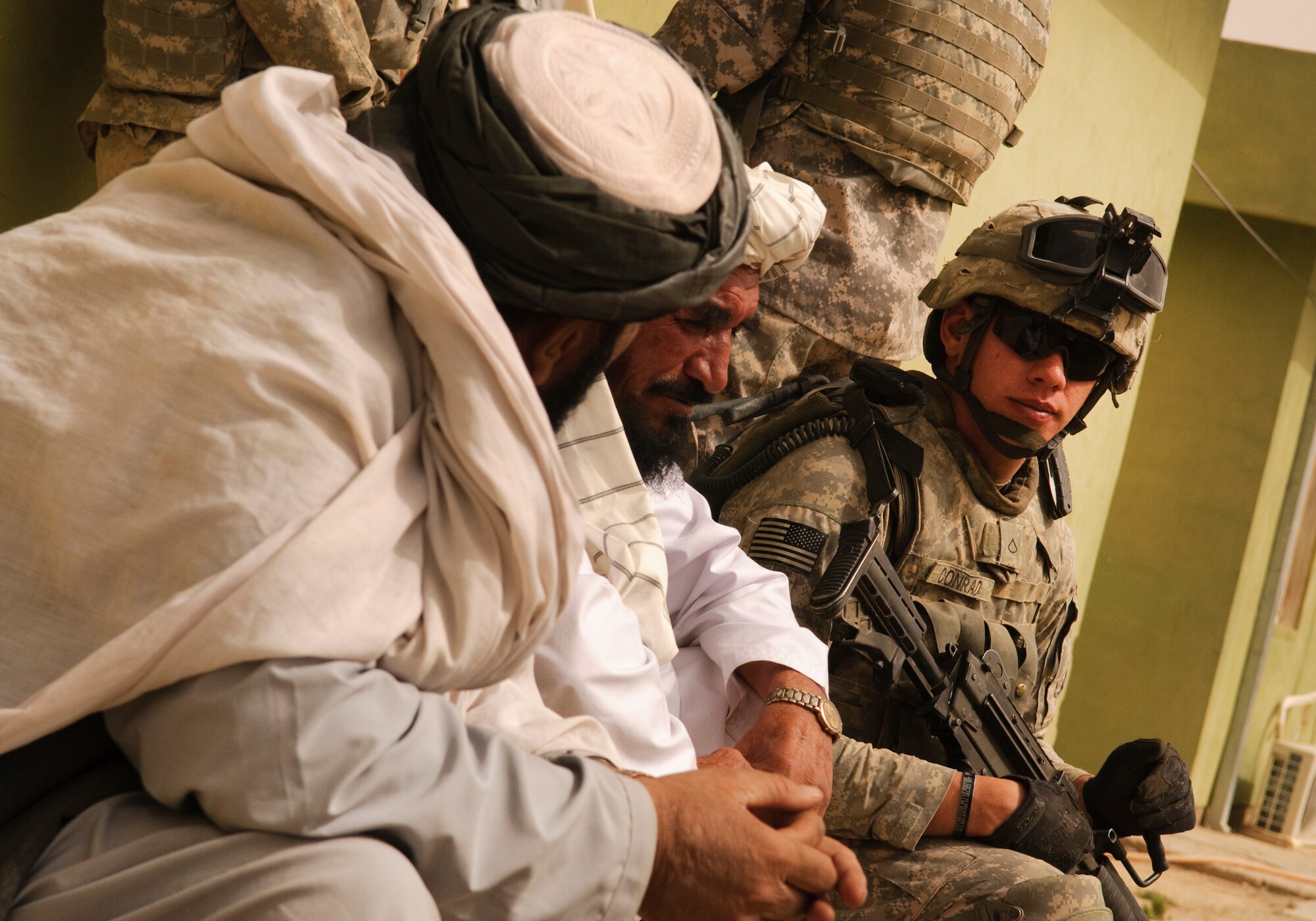 FORWARD OPERATING BASE BULLARD, Afghanistan - U.S. Army Pfc. Michael Conrad, a squad automatic weapon gunner for Provincial Reconstruction Team Zabul and native of Bloomsburg, Pa., listens to two Afghan elders during a shura at the Shah Joy District Chief Abdul Qayum invited local elders to the district center to discuss the upcoming provincial parliamentary elections and to celebrate the end of Ramadan. (U.S. Air Force Photo/Senior Airman Nathanael Callon/Released)
