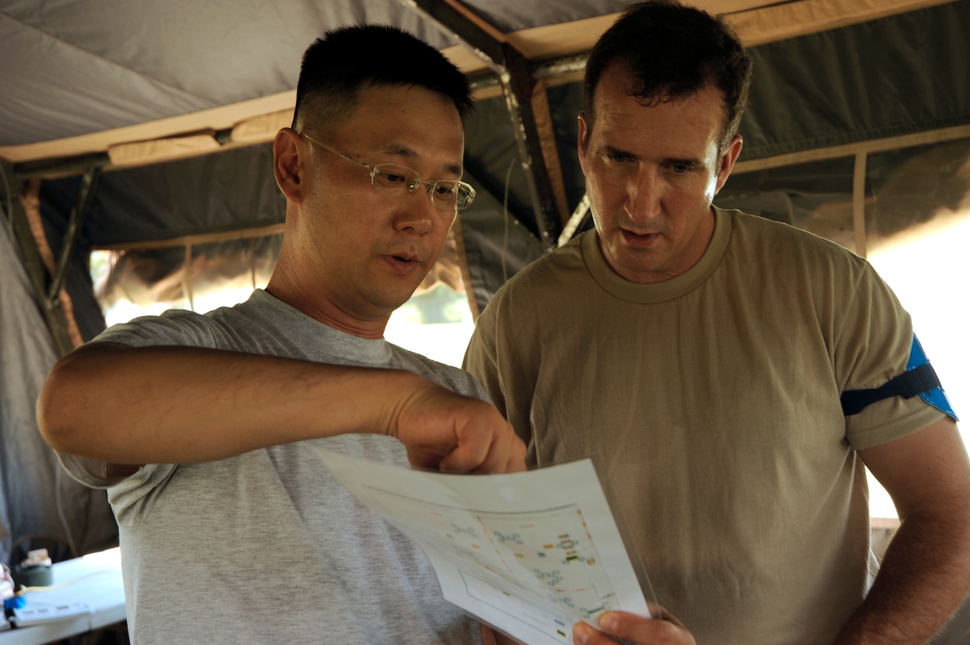 Chaplain (Capt.) John Choi, 6th Air Mobility Wing, shows Maj. Gibb Gary, 6th AMW flight safety chief, the layout of Camp Thunder during a training exercise at MacDill Air Force Base, Fla., Sept. 11, 2010. More than 300 Airmen from the 6th AMW and the 927th Air Refueling Wing participated in the training in preparation for the upcoming Operational Readiness Exercise. (U.S. Air Force photo by: Staff Sgt. Angela Ruiz)