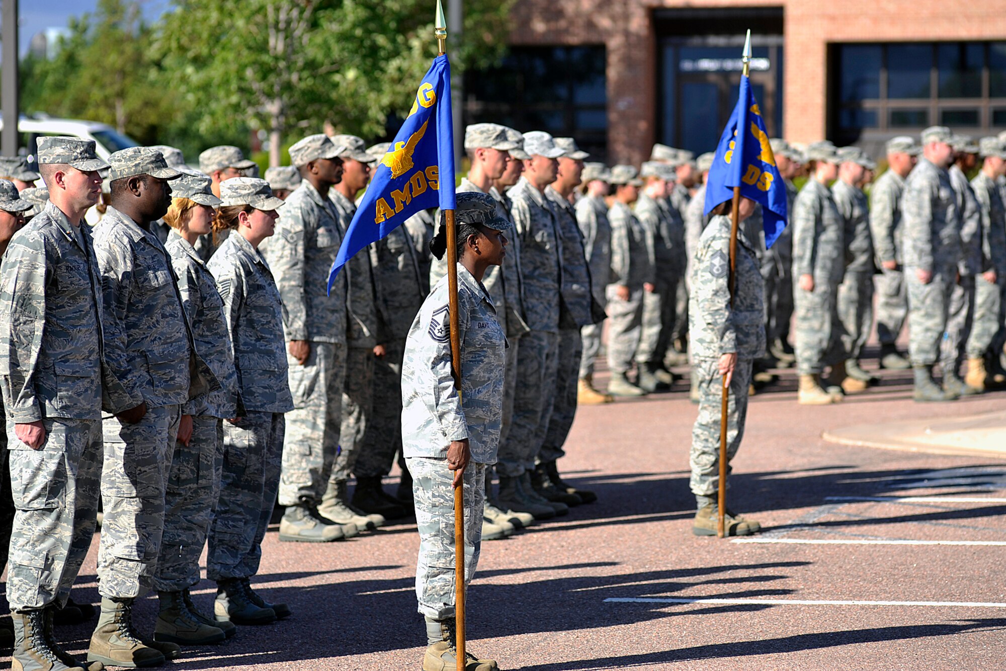 Members of the 21st Medical Group stand in formation as the flag is folded during a retreat ceremony on Aug. 31, at the 21st Wing headquarters building on Peterson Air Force Base. A retreat ceremony is held the last duty day of the month at Building 845, hosted by one of the 21st Space Wing’s groups. The retreat ceremony serves a twofold purpose. It signals the end of the official duty day and serves as a ceremony for paying respect to the flag. (U.S. Air Force photo/ Larry Hulst)