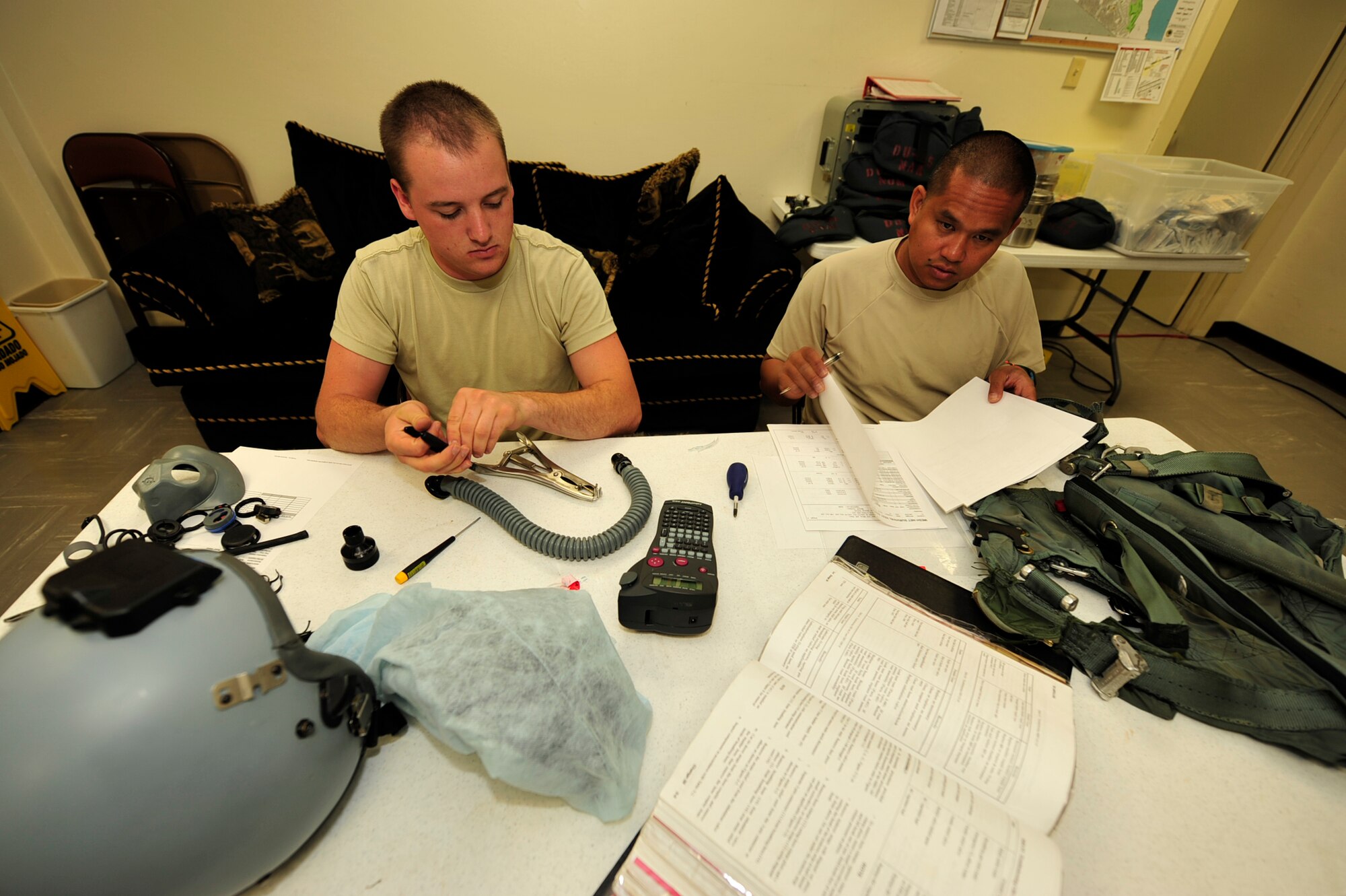 Master Sgt. Calvin Warner, 67th Fighter Squadron, and Airman 1st Class Thomas Adams, 44th Fighter Squadron, perform maintenance on flight crew equipment during the Valiant Shield exercise at Andersen Air Base, Guam, September 14, 2010. Valiant Shield is a joint service exercise that focuses on training and interoperability while responding to a range of mission scenarios.  (U.S. Air Force Photo/Staff Sgt. Lakisha A. Croley)