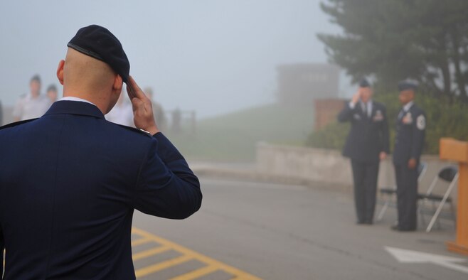 A 51st Fighter Wing Security Forces Airman salutes Col. Patrick Malackowski, 51st FW commander, prior to a reveille ceremony, Sept. 13, 2010 at Osan Air Base, Republic of Korea. National POW/MIA Recognition Day is annually observed in the United States on the third Friday of September. The base will hold observances and ceremonies for the entire week leading up to the national observance. (U.S. Air Force photo/Senior Airman Evelyn Chavez) 