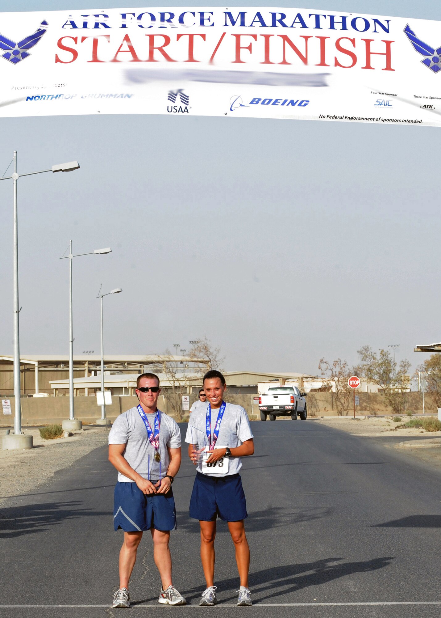 SOUTHWEST ASIA - Capt. Paul Tandberg (left), 737th Expeditionary Airlift Squadron, and Capt. Robin Herndon, 386th Expeditionary Force Support Squadron, pose with their trophies at an undisclosed air base here Sept. 10, 2010, after completing the Air Force Half Marathon. Captain Tandberg was the first male to cross the finish line, with a time of 1 hour, 35 minutes and 38 seconds. Captain Herndon was the first female to finish, with a time of 1 hour, 27 minutes and 54 seconds. The 386th Expeditionary Force Support Squadron hosted the event to support the Annual Air Force Marathon, which will take place Sept. 18 at Wright-Patterson Air Force Base, Ohio. The half marathon is a challenging 13.1-mile run. (U.S. Air Force photo by Senior Airman Laura Turner)