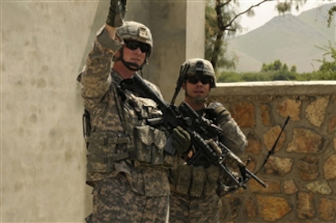 U.S. Air Force Staff Sgt. John Kingsley (left), a radio transmission operator with the Nangarhar Provincial Reconstruction Team, and U.S. Army 1st Lt. John Cerra, a security forces platoon leader with the team, look toward the location of suspected fire near Jalalabad, Afghanistan, on Sept. 8, 2010.  Members of the team were inspecting a reconstruction team funded project when the attack occurred.  