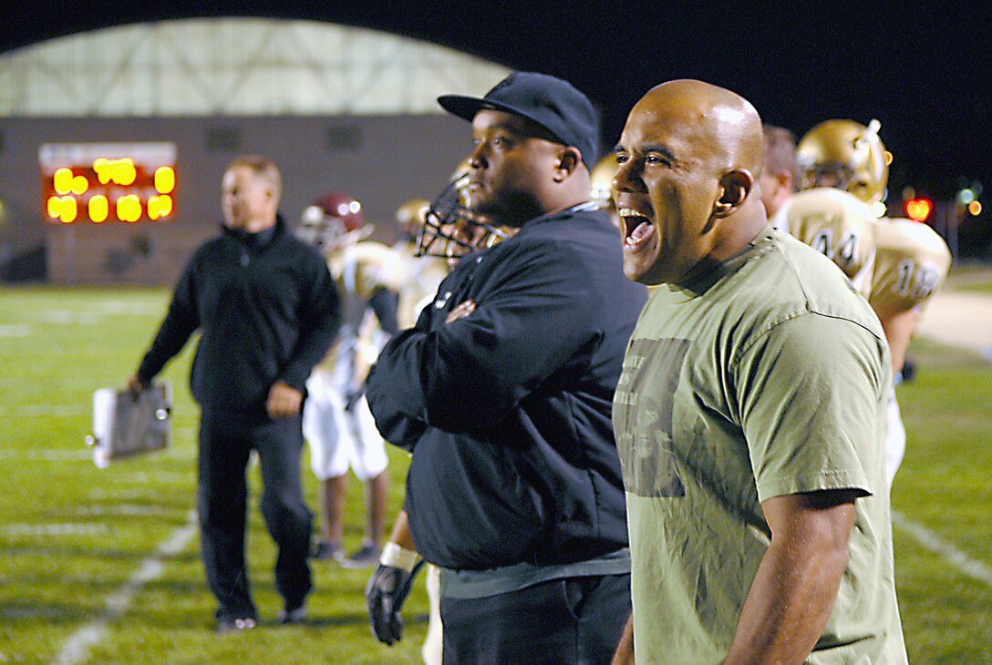 Coach, Staff Sgt. James Corona, right, shouts words of encouragement and praise to his players on the field after taking down a player from the opposing team.
