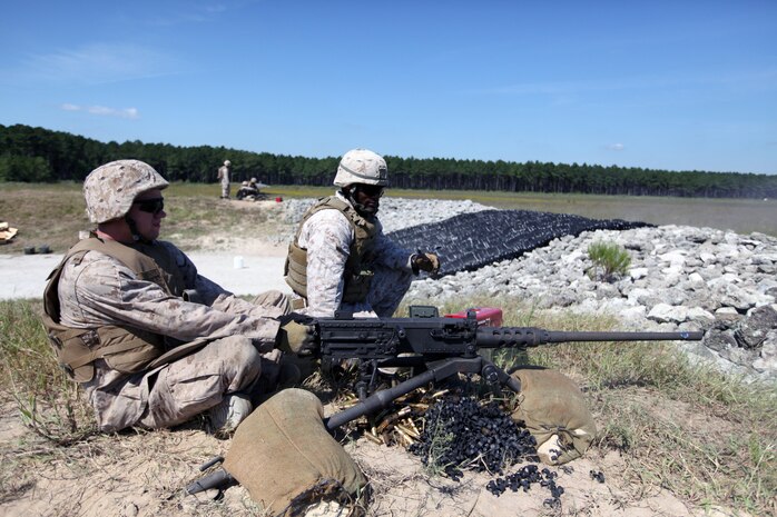 Pfc. Cristopher J. Haire (left), a hygiene equipment operator with support engineer platoon, Combat Logistics Battalion 8, 2nd Marine Logistics Group, shoots the .50 caliber heavy machine gun during the live fire exercise Sept. 16, 2010, aboard Camp Lejeune, N.C.  The Marines participated in a week-long Machine Gunners Course at the Battle Skills Training School in preparation for their upcoming deployment to Afghanistan. (U.S. Marine Corps photo by Lance Cpl. Bruno J. Bego)