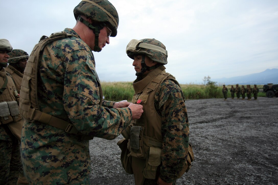 Staff Sgt. Rodrigo B. AriasHernandez, right, with Headquarters Battery, 3rd Battalion, 12th Marine Regiment, 3rd Marine Division, III Marine Expeditionary Force, is presented the Bronze Star Award with Combat V for his actions while deployed to Operation Enduring Freedom by Maj. Gen. James B. Laster, the commanding general of 3rd MarDiv., in an awards ceremony during the Artillery Relocation Training Program exercise on the East Fuji range Sept. 15.