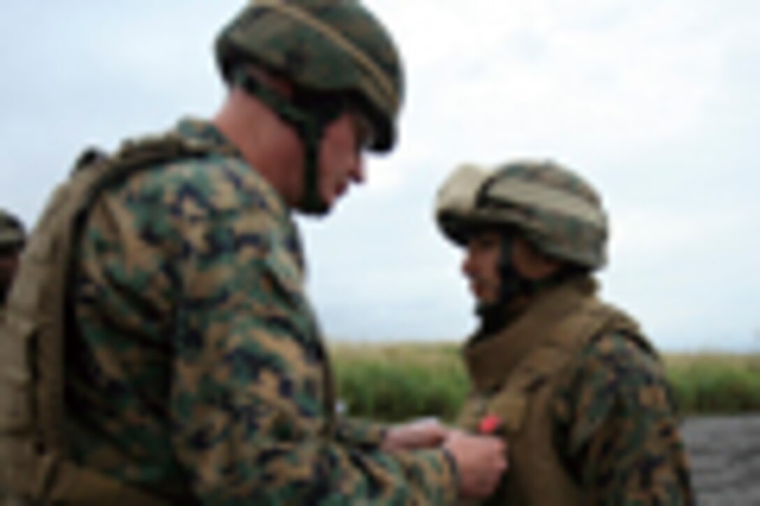Staff Sgt. Rodrigo B. AriasHernandez, right, with Headquarters Battery, 3rd Battalion, 12th Marine Regiment, 3rd Marine Division, III Marine Expeditionary Force, is presented the Bronze Star Award with Combat V for his actions while deployed to Operation Enduring Freedom by Maj. Gen. James B. Laster, the commanding general of 3rd MarDiv., in an awards ceremony during the Artillery Relocation Training Program exercise on the East Fuji range Sept. 15.