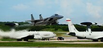 ANDERSEN AIR FORCE BASE, Guam ? Two E-3 Sentries  are seen in the background as an F-15C Eagle takes off on the Andersen flightline while participating in the Valiant Shield 2010 exercise, here Sep. 16.  The aircraft are a key component of the major joint flying exercise that kicked off this week. (U.S. Air Force photo by Airman 1st Class Jeffrey Schultze)
