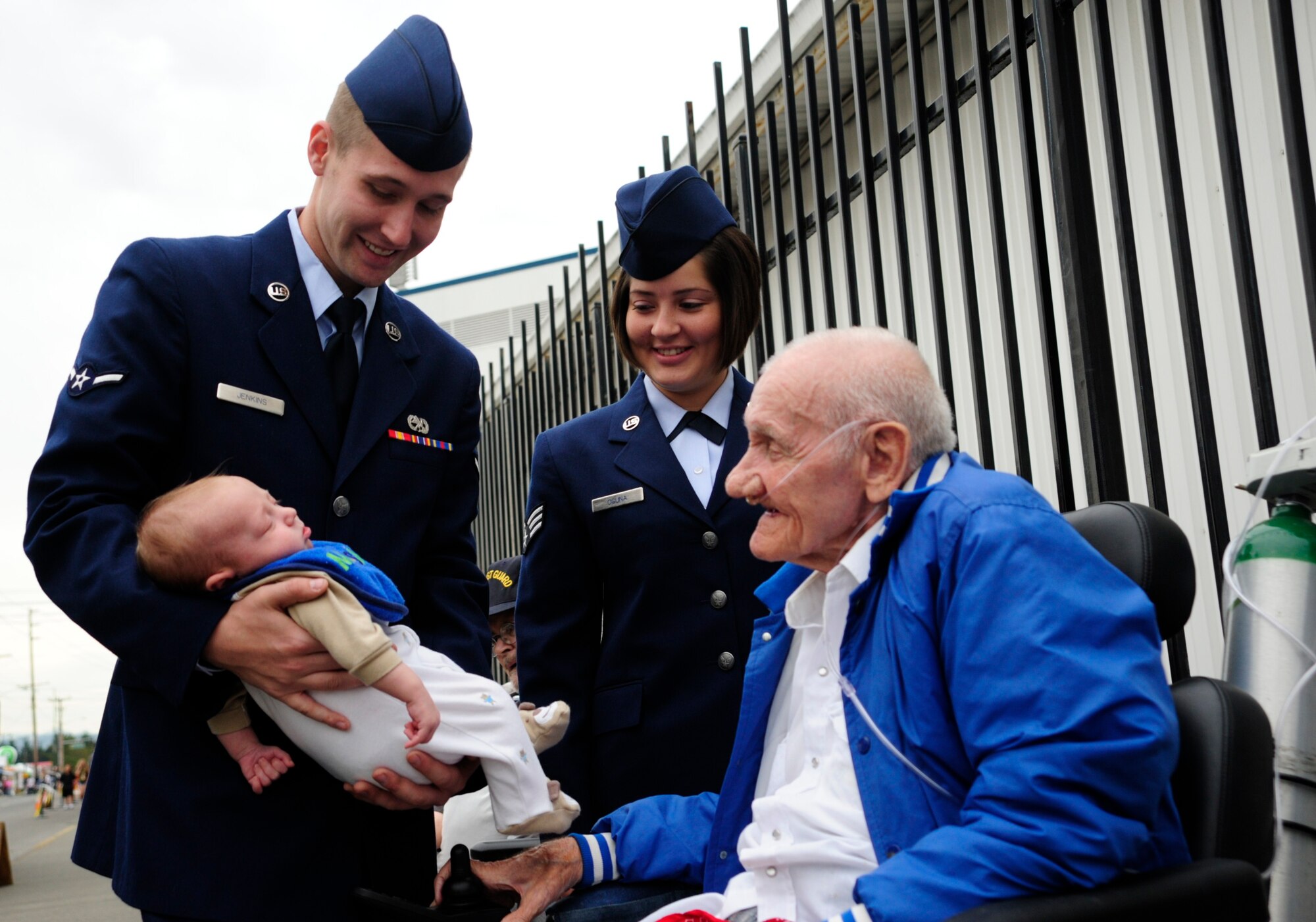 Airman Darren Jenkins, left, 62nd Aircraft Maintenance Squadron, and Senior Airman Cassie Osuna, middle, 86th Aerial Port Squadron ramp services craftsman, both assigned to Joint Base Lewis-McChord, Wash., introduce Airman Jenkins' son to Mac McFarland, retired Navy Chief Petty Officer and resident at the Washington State Soldiers Home, Sept. 15 at the Puyallup Fair in Puyallup, Wash. (U.S. Air Force Photo/Airman Leah Young)