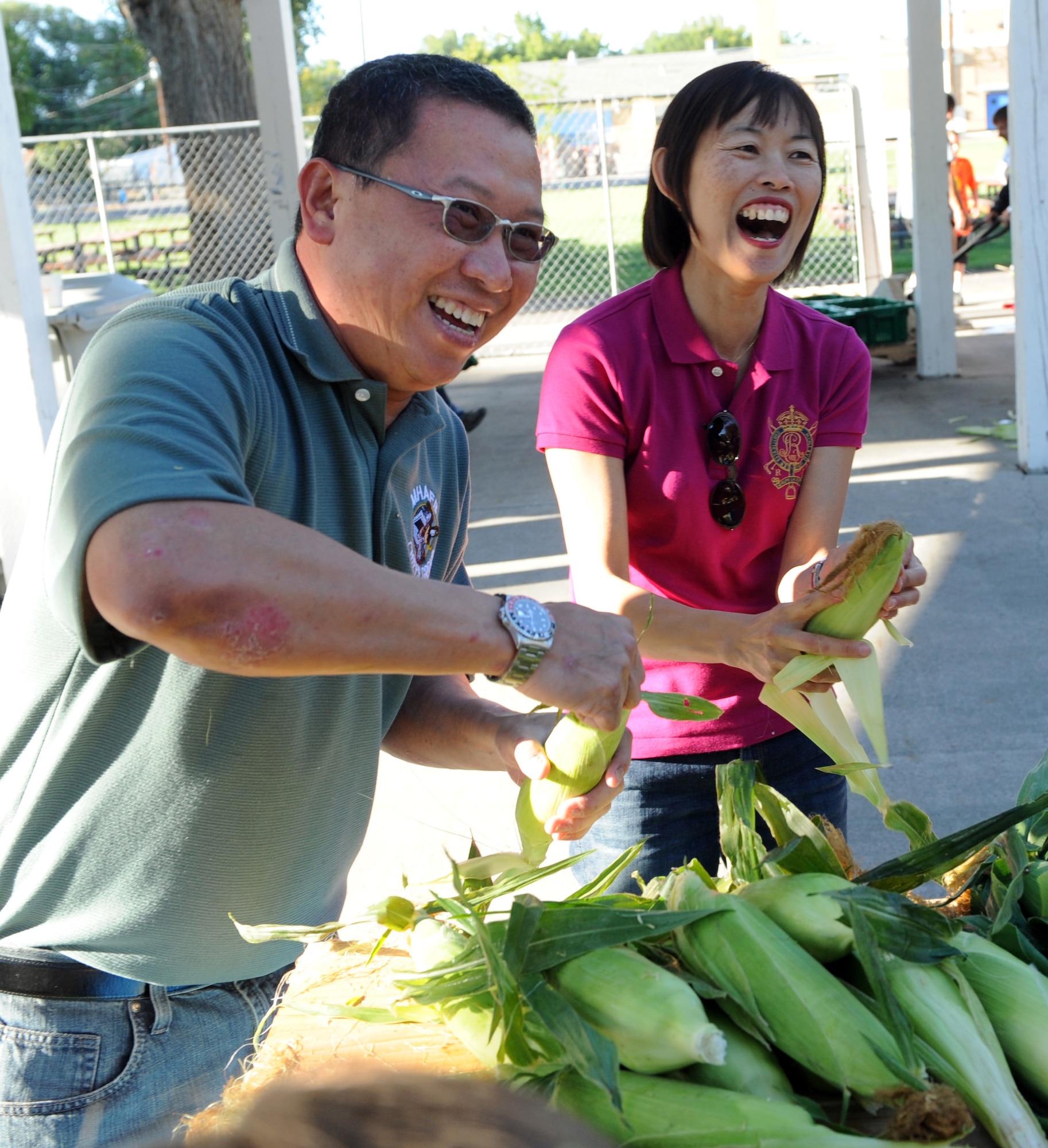 MOUNTAIN HOME AIR FORCE BASE, Idaho – Chief Master Sgt. Alfred Chow, 428th Fighter Squadron superintendent, and his wife Grace Chow husk corn during the annual corn shucking competition at Carl Miller Park Sept 10. After the competition, the corn was used in a free lunch for attendants during the 50th anniversary of the Air Force Appreciation Day parade and festival.  (U.S. Air Force photo by Senior Airman Debbie Lockhart)