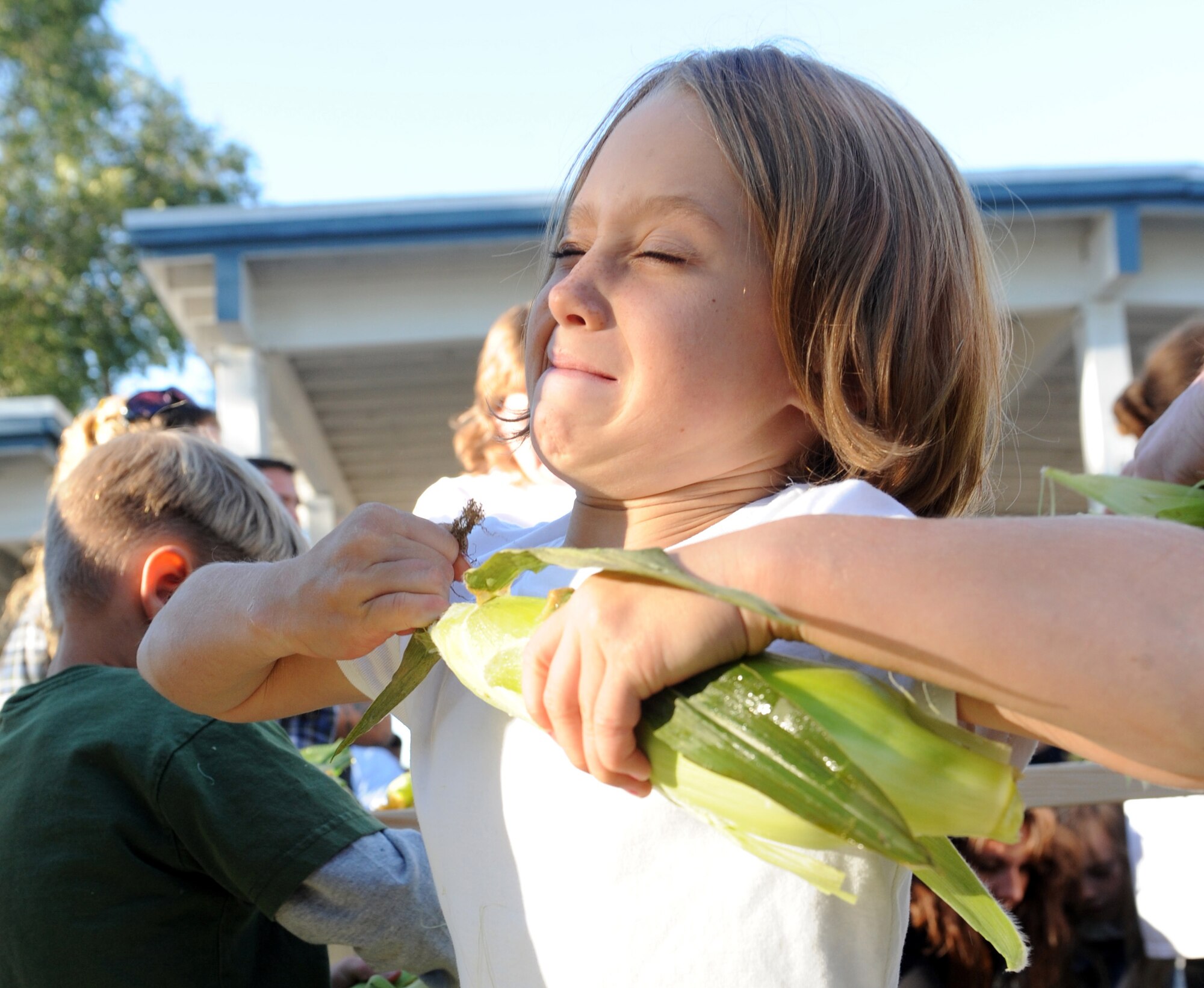 MOUNTAIN HOME AIR FORCE BASE, Idaho -- Sarah Brown pulls the husk off a piece of corn during the annual corn shucking competition at Carl Miller Park Sept 10. After the competition, the corn was used in a free lunch for attendants during the 50th anniversary of the Air Force Appreciation Day parade and festival. (U.S. Air Force photo by Senior Airman Debbie Lockhart)