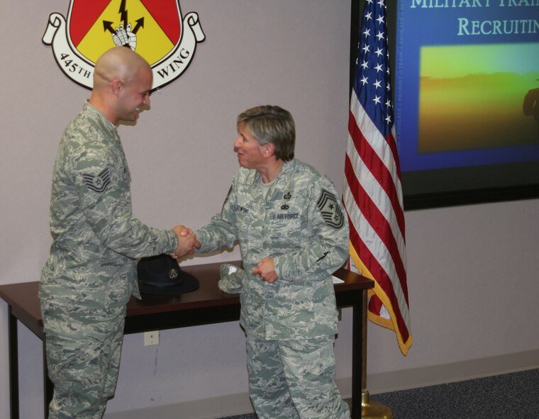 WRIGHT-PATTERSON AIR FORCE BASE, Ohio - Tech. Sgt. Derek Sensenig, a traditional reserve military training instructor with the 433rd Training Squadron, receives a wing coin from Chief Master Sgt. Peri Rogowski, 445th Airlift Wing command chief, after he and Senior Master Sgt. Julie Begley, superintendent of the 433rd Training Squadron, and an air reserve technician, held two information sessions during the wing’s September unit training assembly. (U.S. Air Force photo/Capt. Caroline Wellman)