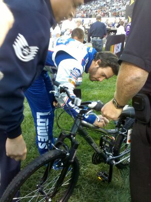 Jimmy Johnson, NASCAR driver, signs a bicycle for L.J., a boy who has contracted a rare form of luekemia, Sept.11, 2010, at a race in Richmond, Va. Through the efforts of Tech. Sgt. Michael Meinhold and Mr. Frank Russo of Dover Air Force Base, Del., L.J. will recieve this bike, signed by NASCAR drivers Jimmy Johnson and Danny Hamlin, to replace the one that was stolen from him earlier this year. (Courtesy photo) 