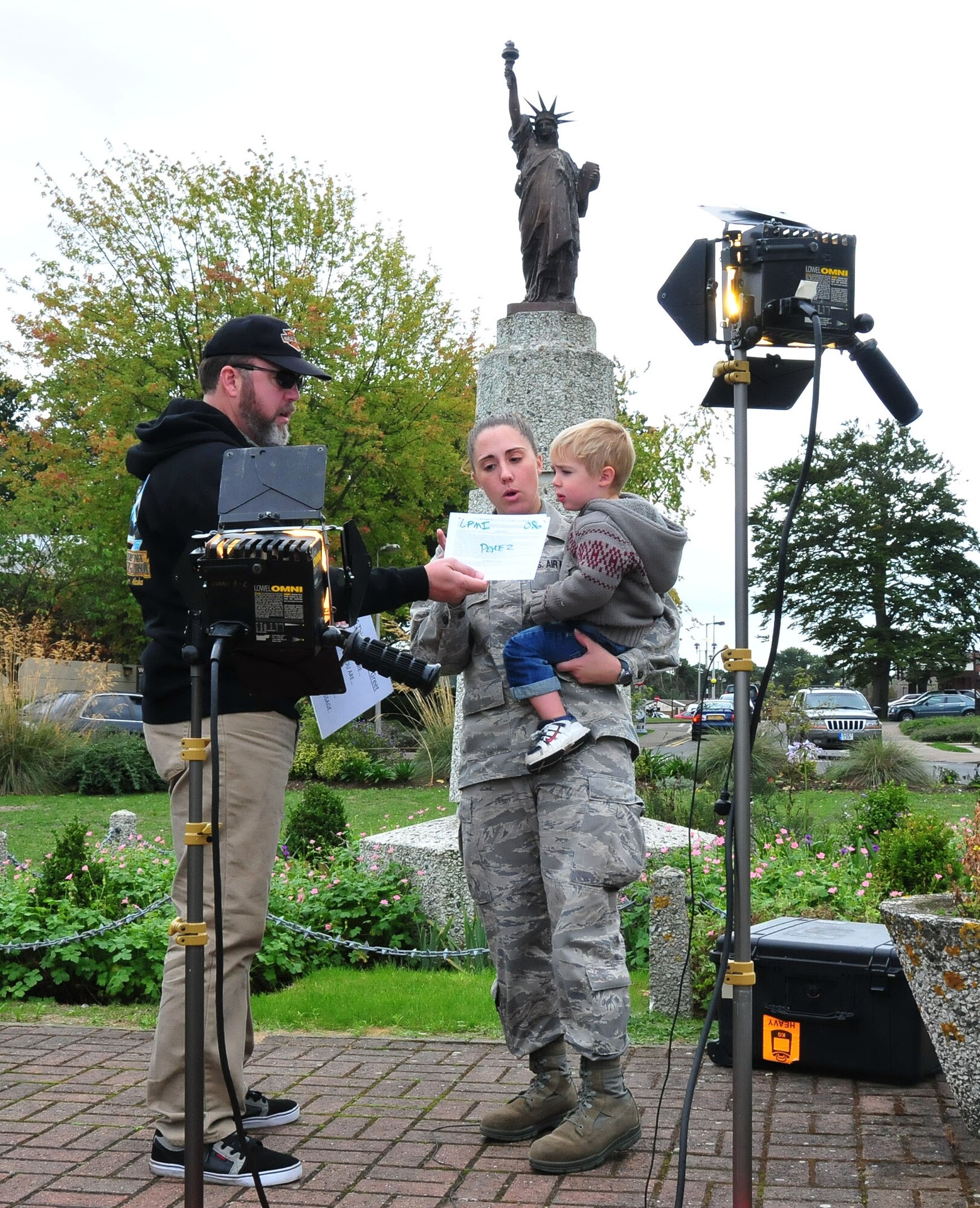 ROYAL AIR FORCE LAKENHEATH, England - Erich Schwab (left) of the Air Force News Hometown Greeting team goes over the video script with Senior Airman Michelle Perez, 48th Logistics Readiness Squadron material management apprentice, and her two year old son Landyn Sept.15, 2010. The Hometown News team visits annually to assist Liberty Warriors and their families with video messages to be displayed on local television stations in their hometown. (U.S. Air Force photo/Staff Sgt. Connor Estes)s)