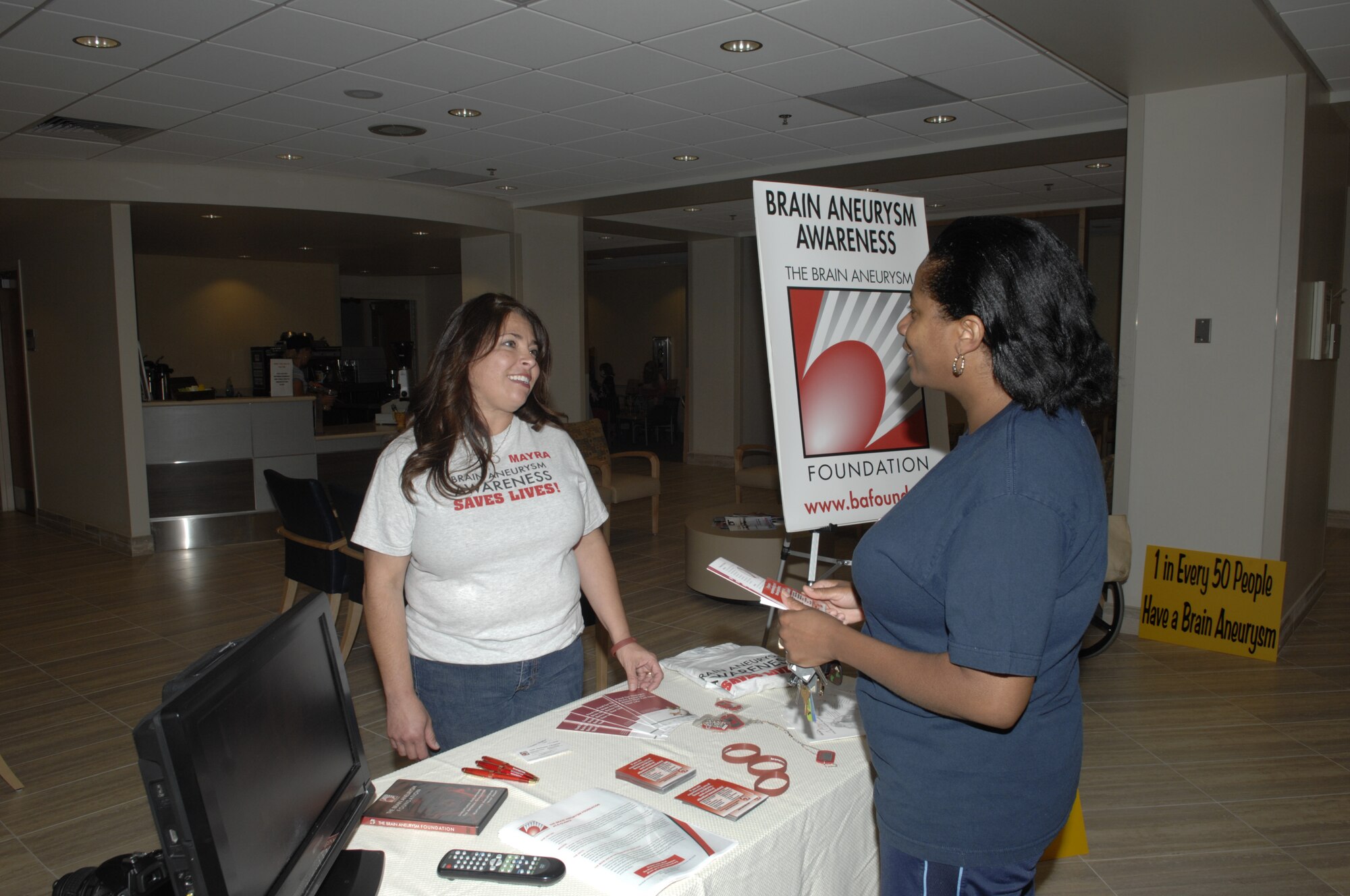 SCOTT AIR FORCE BASE, Ill. -- Mayra Kent speaks to Brenda Simmons about brain aneurysm awareness at the Scott Family Clinic Monday. Mrs. Kent hopes that by speaking to people she will gain interest in a brain aneurysm support group for the local area, similar to what she accomplished in the San Antonio area where she was previously stationed with her husband Lt. Col. Robert Kent, 375th Flight Medicine Flight commander. (U.S. Air Force photo/Senior Airman Amber R. Kelly-Herard) 