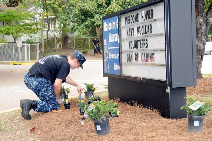 Fireman Nicholas Cage, from Daytona Beach, Fla., assigned to Naval Nuclear Power Training Command at Naval Weapons Station Charleston, performs landscaping at Malcolm C. Hursey Elementary School during the annual Day of Caring event. More than 2,500 Sailors and Airmen throughout the Charleston area participated in the community service event. (U.S. Navy photo by Mass Communication Specialist 1st Class Jennifer R. Hudson) 