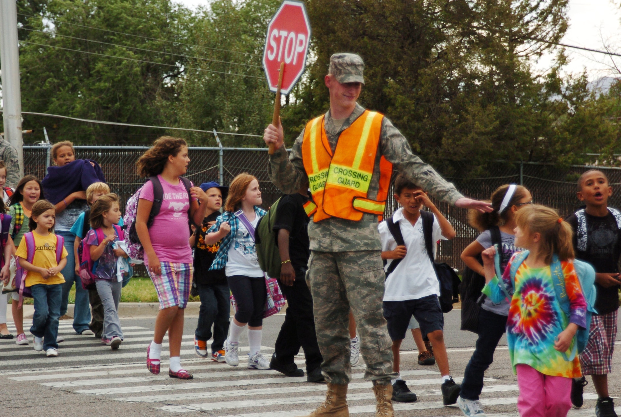 As a cross guard, it is Airman 1st Class Stephen Elliott, 75th Air Base Wing Communications and Information Directorate, duty to make sure that the school kids get across the street safely. There are many crosswalks around Hill Air Force Base that drivers need to be aware of. As a precaution, building 1204 and many other crosswalks around Hill Air Force Base have orange flags posted so that people can wave the flags as they are crossing the street to make drivers aware.  (Air Force photo by Airman 1st Class Melissa Dearstone)
