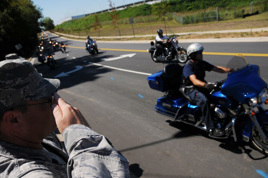 Charlotte, N.C.  --  Chief Master Sgt. Mark Hovis and other Airmen assigned to the 145th Airlift Wing, NC Air National Guard pay their respects as the funeral procession of PFC James McClamrock passes by the NC Air Guard base in Charlotte. McClamrock was killed September 7th, 2010 in Balad, Iraq. The procession was headed to McClamrocks hometown of Concord, NC, where he will be laid to rest. Photo by Tech Sgt. Brian E. Christiansen, N.C. Air National Guard.