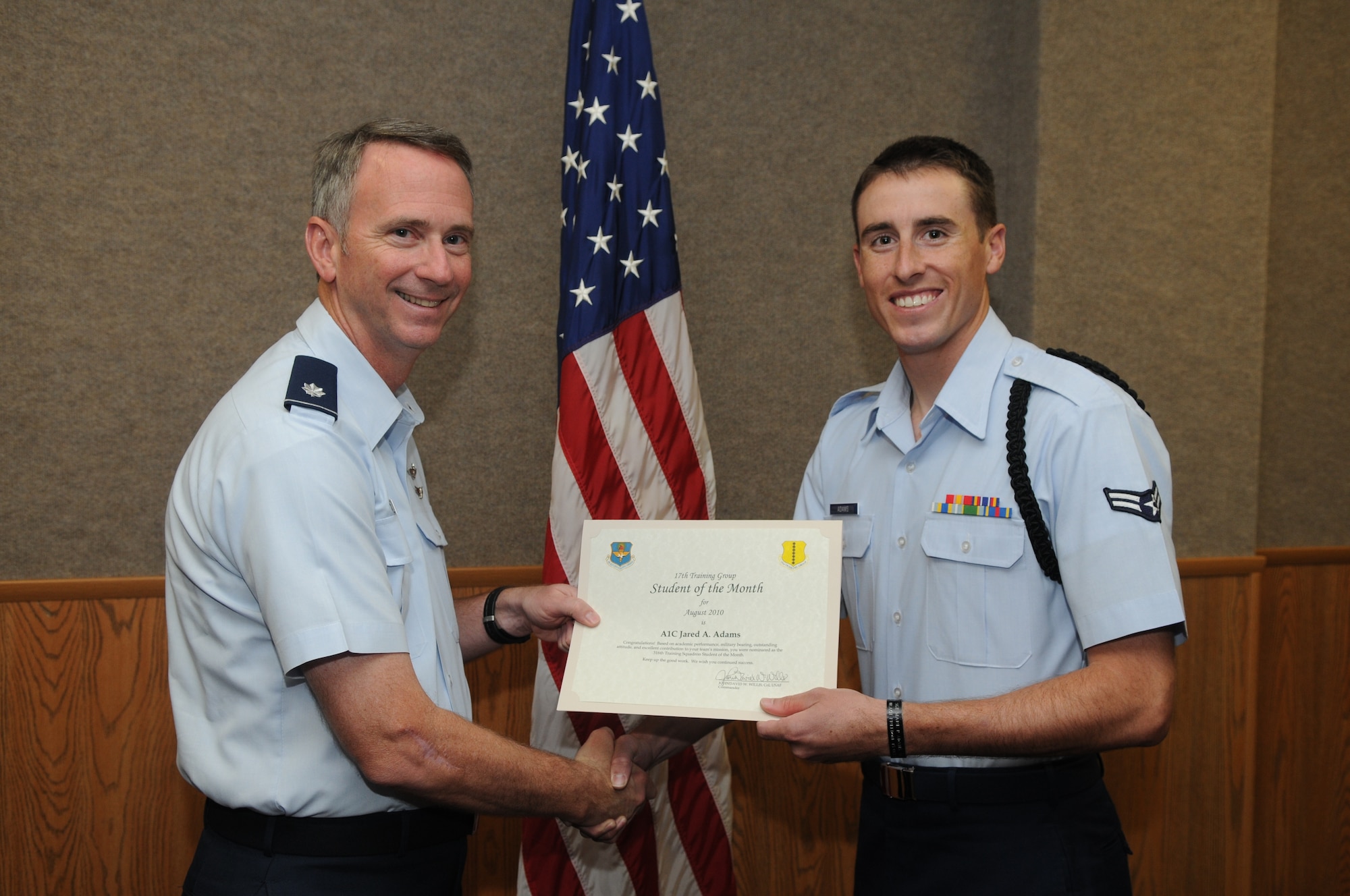 Airman 1st Class Jared Adams, 316th Training Squadron, accepts his August Student of the Month award from Lt. Col. Andrew Cupp, 17th Training Group Deputy Commander. (U.S. Air Force photo/Airman 1st Class Clayton Lenhardt)