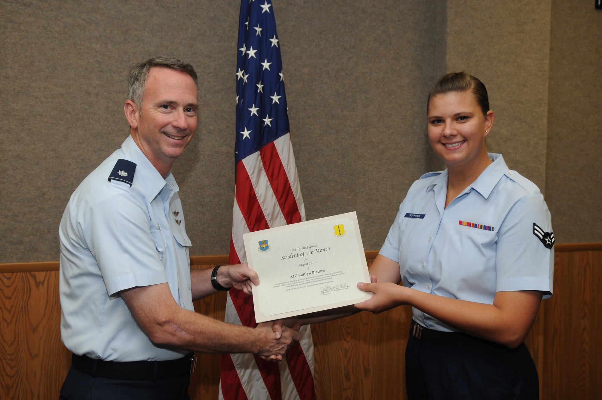 Airman 1st Class Kaitlyn Blattner, 315th Training Squadron, accepts her August Student of the Month award from Lt. Col. Andrew Cupp, 17th Training Group Deputy Commander. (U.S. Air Force photo/Airman 1st Class Clayton Lenhardt)